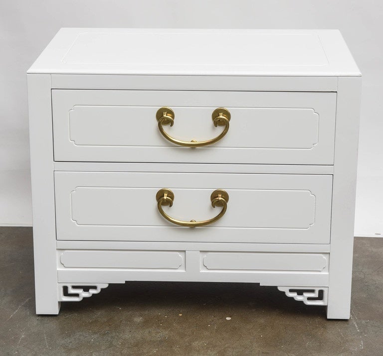 Beautifully chic pair of white lacquered high style, Hollywood Regency end tables or nightstands with solid brass fittings.