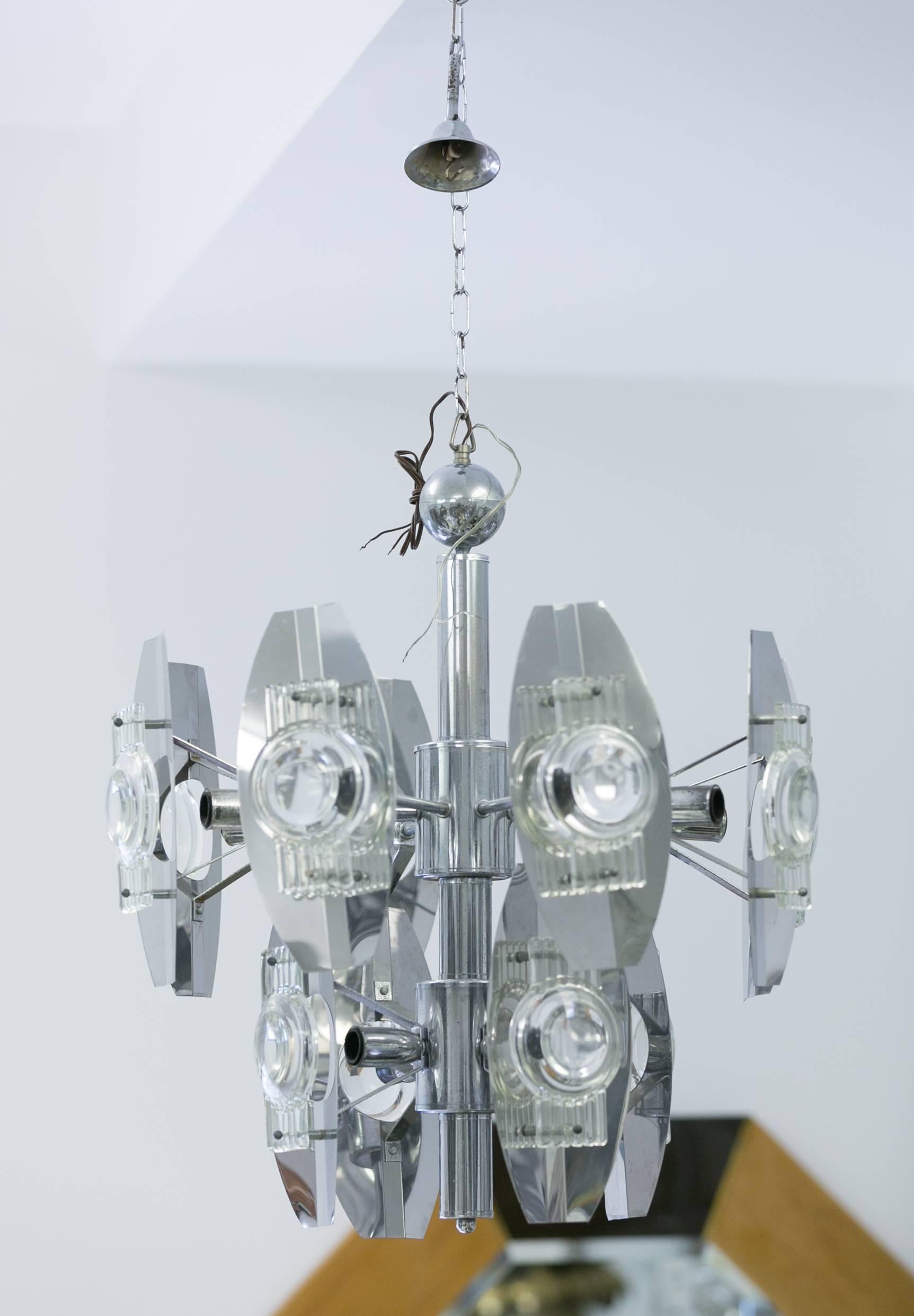 Twelve-light Chrome Chandelier in Oscar Torlasco style
with optical Murano glass reflectors attached
to chrome screens mounted on center 
rod with a ball at top.
Labeled.