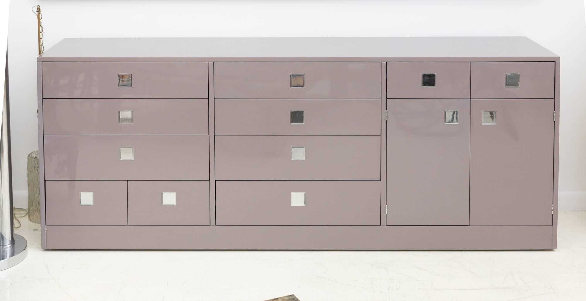 Credenza by Milo Baughman
for Directional Custom Collection, featuring
Lacquer piano finish, multiple drawers
and a shelf behind double doors,
Original Super cool recessed square
pulls in nickel finish.
Metal tag inside top left drawer.
  