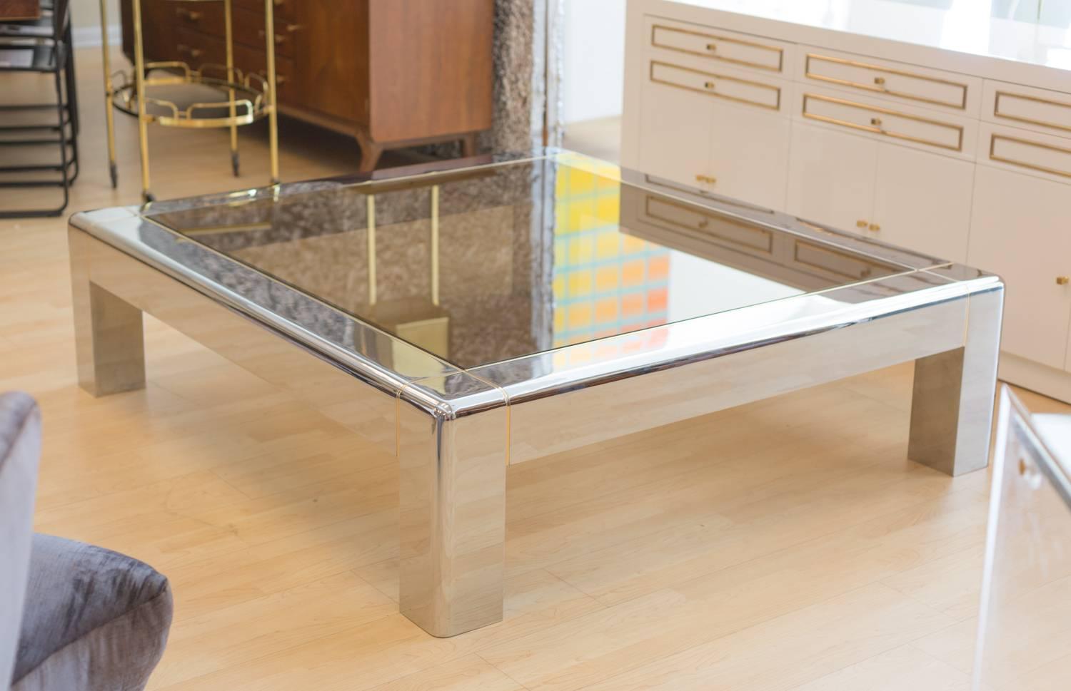 1980s coffee table by Karl Springer 
With nickel-plated mirror finish frame,
 brass strips around inserted smoky glass top.
  