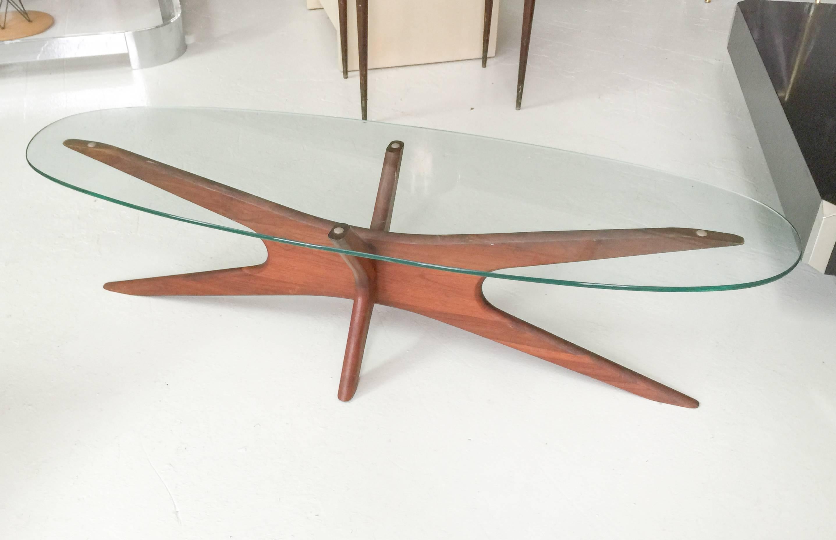 Elongated Jacks cocktail table by Adrian Pearsall
in walnut with elliptical glass top.

