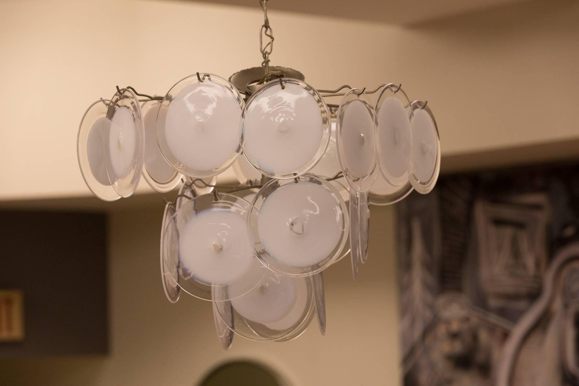 Disk chandelier in Murano glass by Vistosi.
 6"dia. white and clear glass disks 
mounted on nickel finished Wire frame 
with 3 sockets, matching Chain with 
decorative ceiling mount.