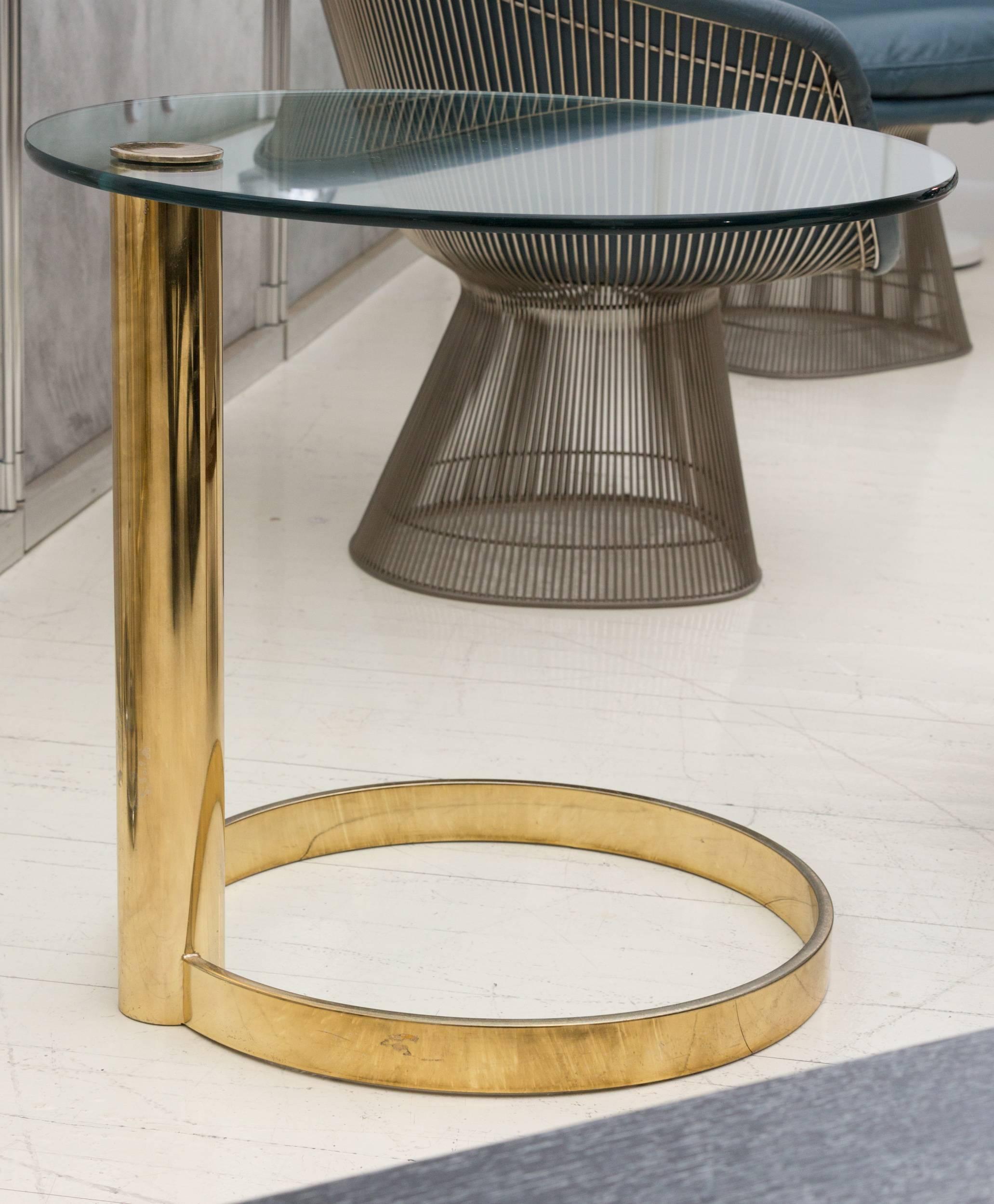 Brass and glass Side Table by Pace Collection.
26.5" diameter, 0.5" thick glass top cantilevered 
from a 3" diameter brass post on 20" diameter 
2" H, 0.5" thick ring base. 
Some patina to the polished brass finish.