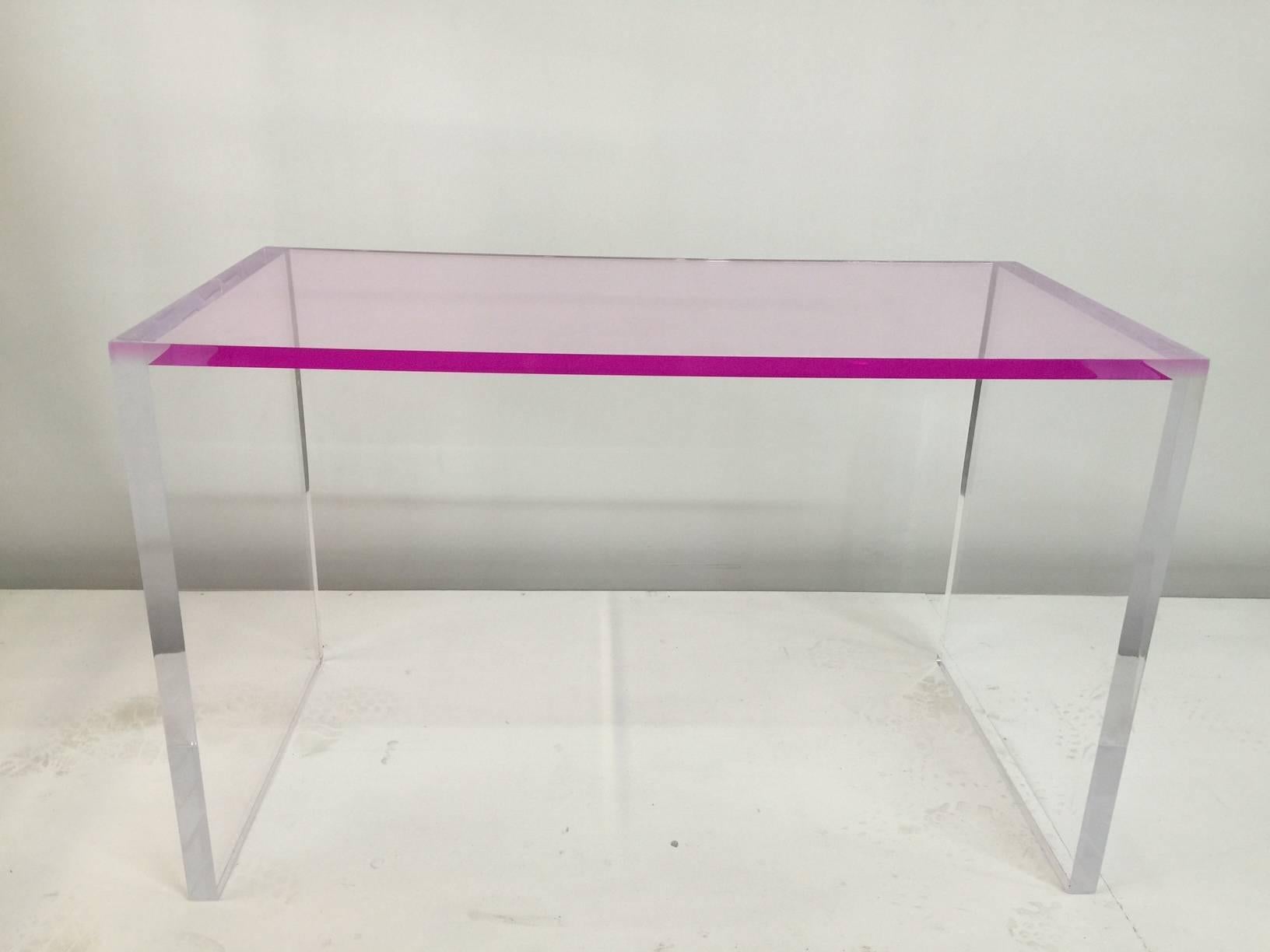 This playful yet elegant desk and bench features a vivid pink top and clear acrylic laterals. The bench has a custom pink bench cushion which can be affixed with the central grommet holes pictured in the detail images.

Bench dimensions: 18 inches
