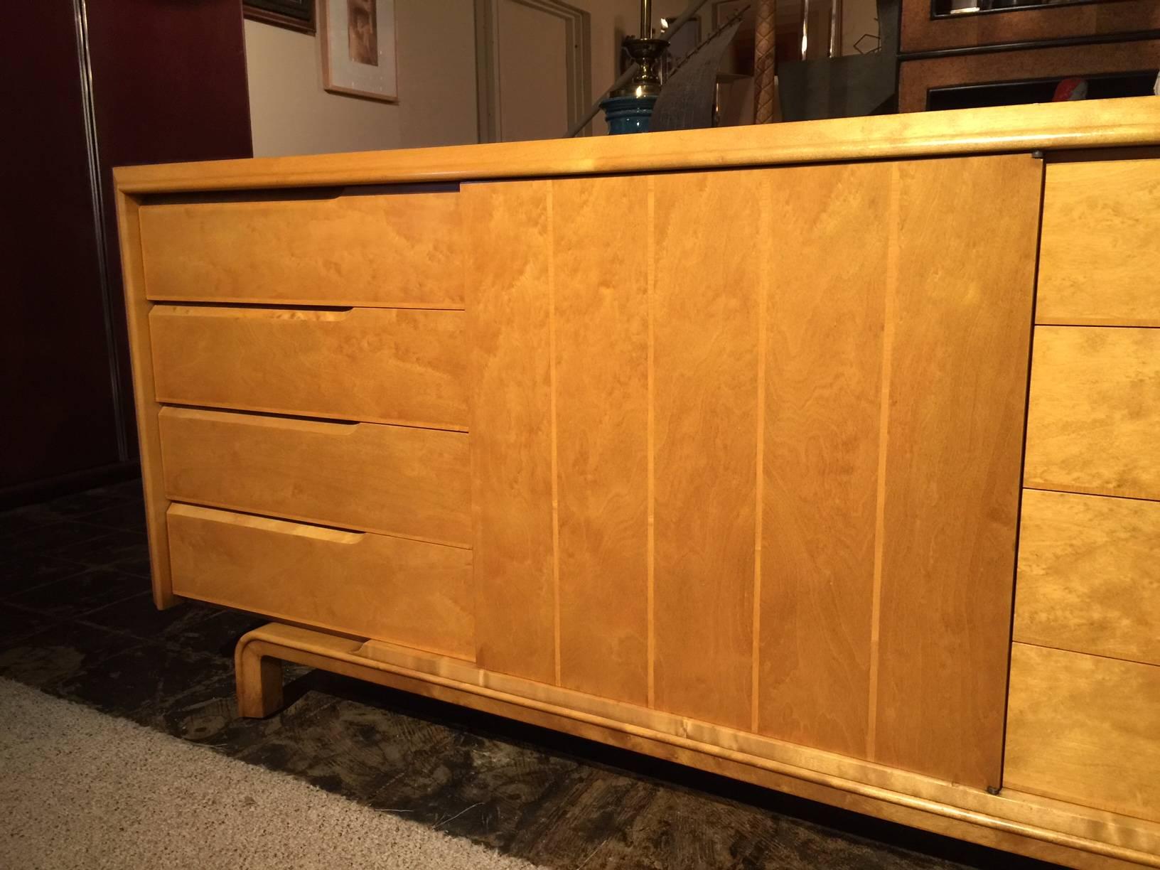 Armoire américaine moderne du milieu du siècle, rarement vue, à huit tiroirs latéraux à gauche et à droite. Porte à ouverture centrale à poussoir avec tiroir et étagères ouvertes.

Les pieds sont incurvés, en bois courbé et reprennent le motif