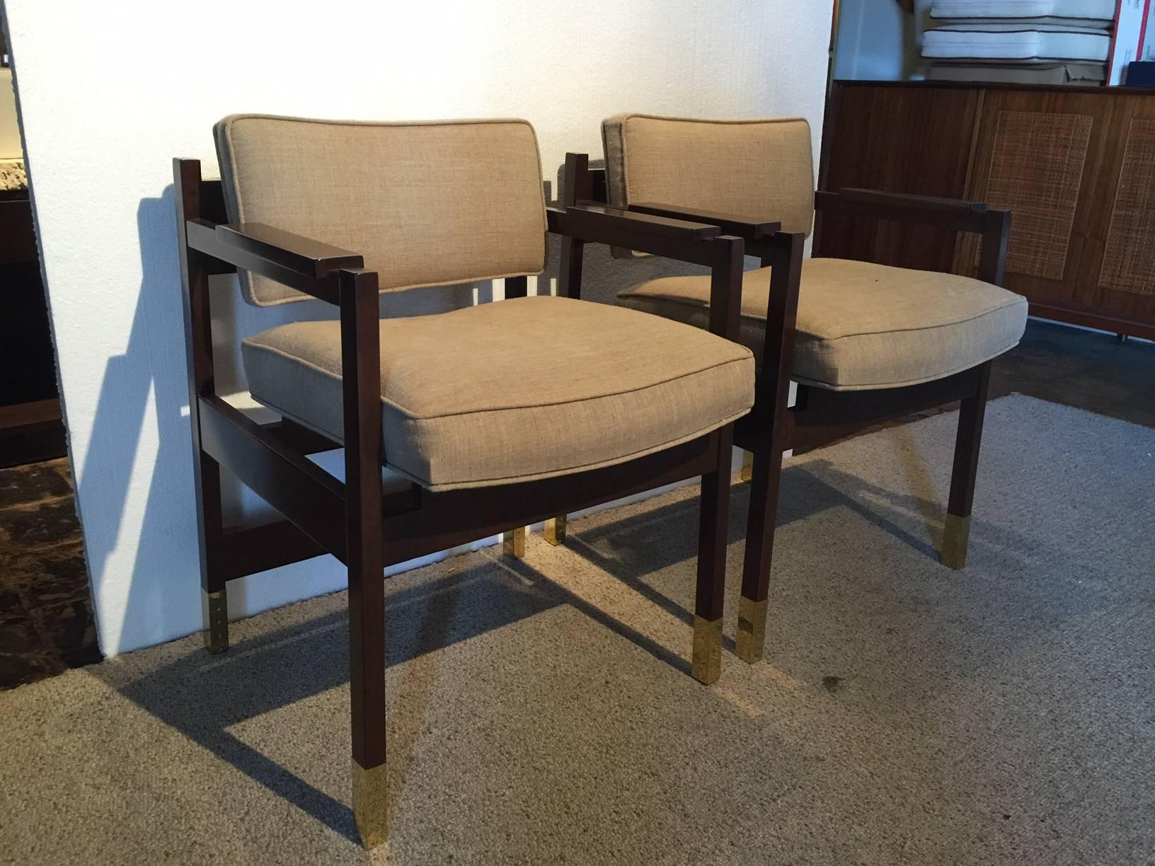 Vintage linen upholstery on these Sornay style armchairs featuring oversized brass sabots on dark brown finish stain.