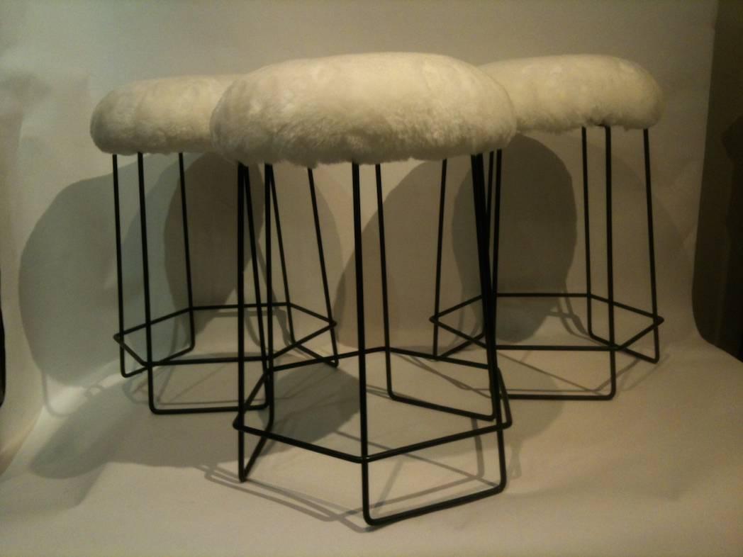 Mid-Century Modern A Set of Three Black Wire and Shearling Stools in the style of Jean Royere