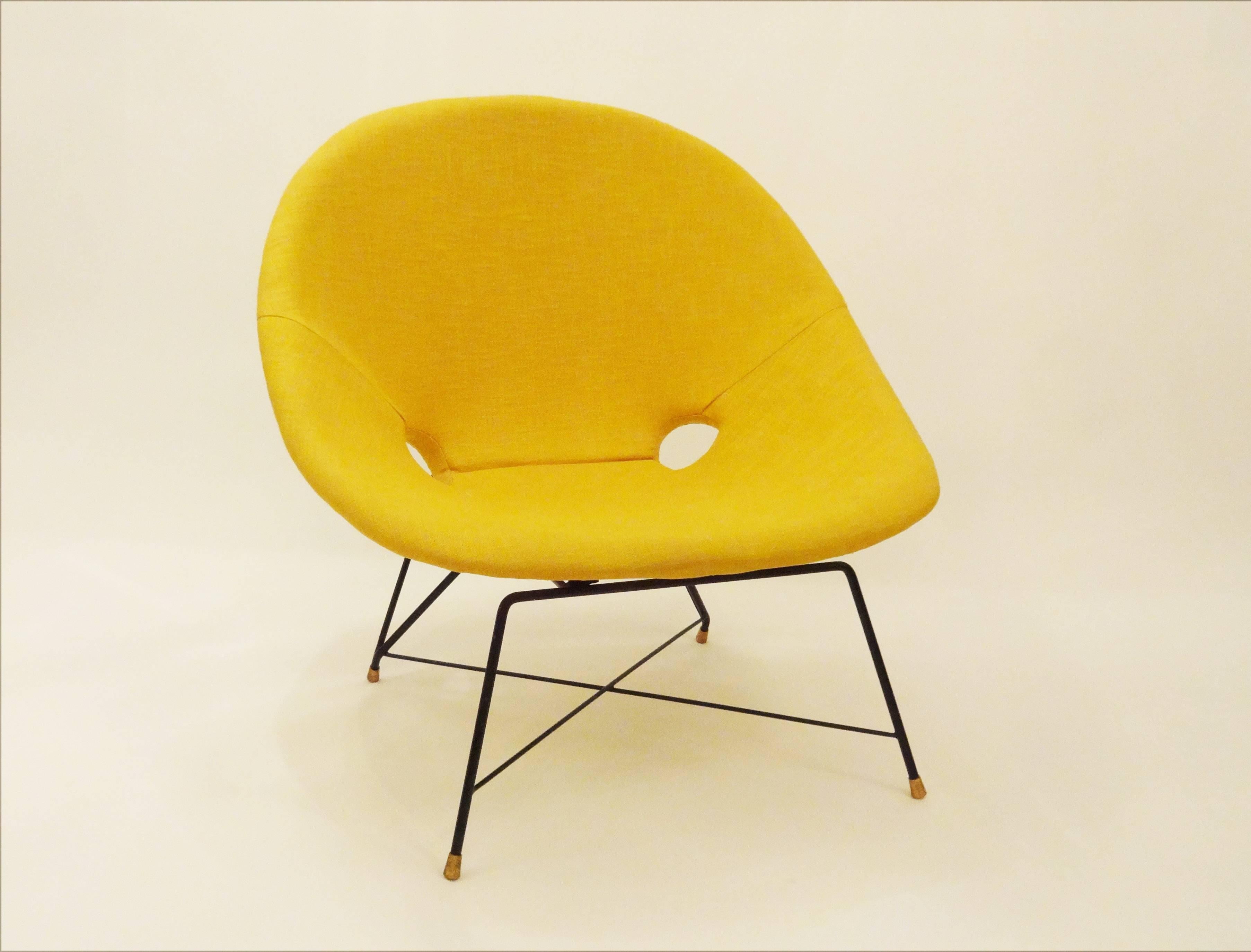 Pair of modernist club chairs each featuring frames of blackened steel onto which sit one-piece shaped seat and back rests with two round cut outs at the back seat area. The clubs have new upholstery in a sunflower yellow. Basket weave and also