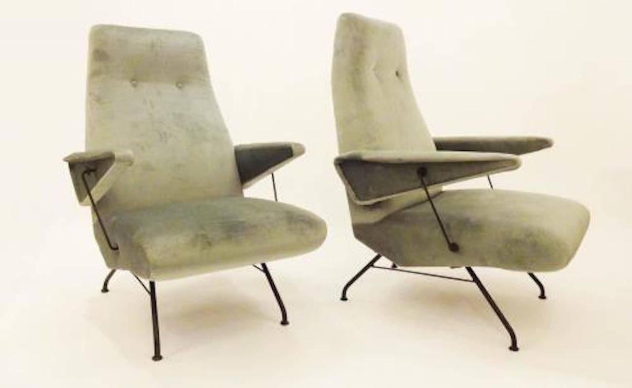 Pair of Mid-Century club or lounge chairs each featuring tight seats and backs with two button detail, shaped arms with blackened steel supports and splayed legs and feet also done in blackened steel. The clubs also feature all new upholstery done