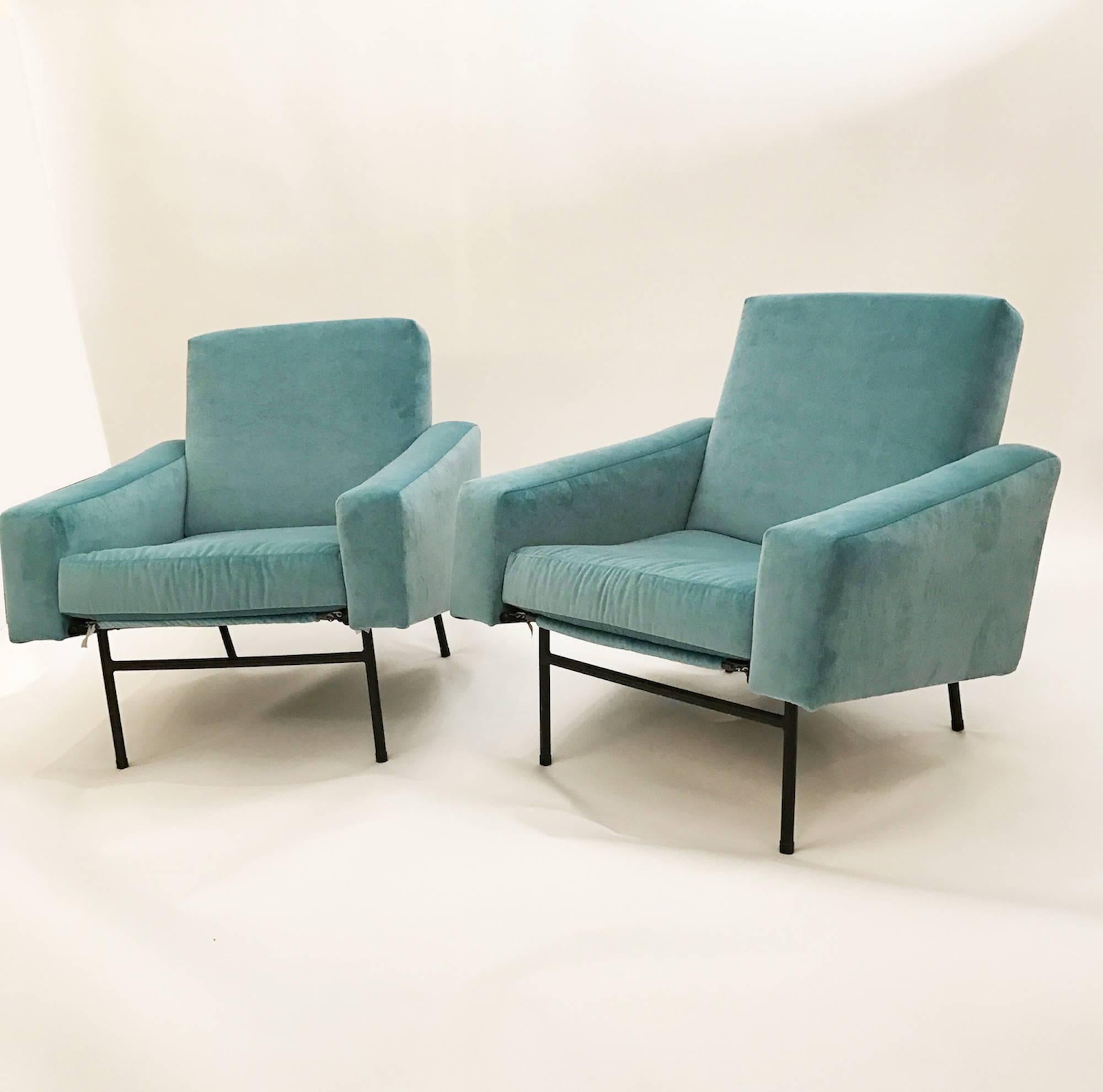 Pair of club chairs each featuring tight seats and backs with angled tight armrests which are supported by a blackened steel frame with splayed legs. The clubs also feature all new upholstery done in a Tiffany blue velvet. Pierre Guariche, France,