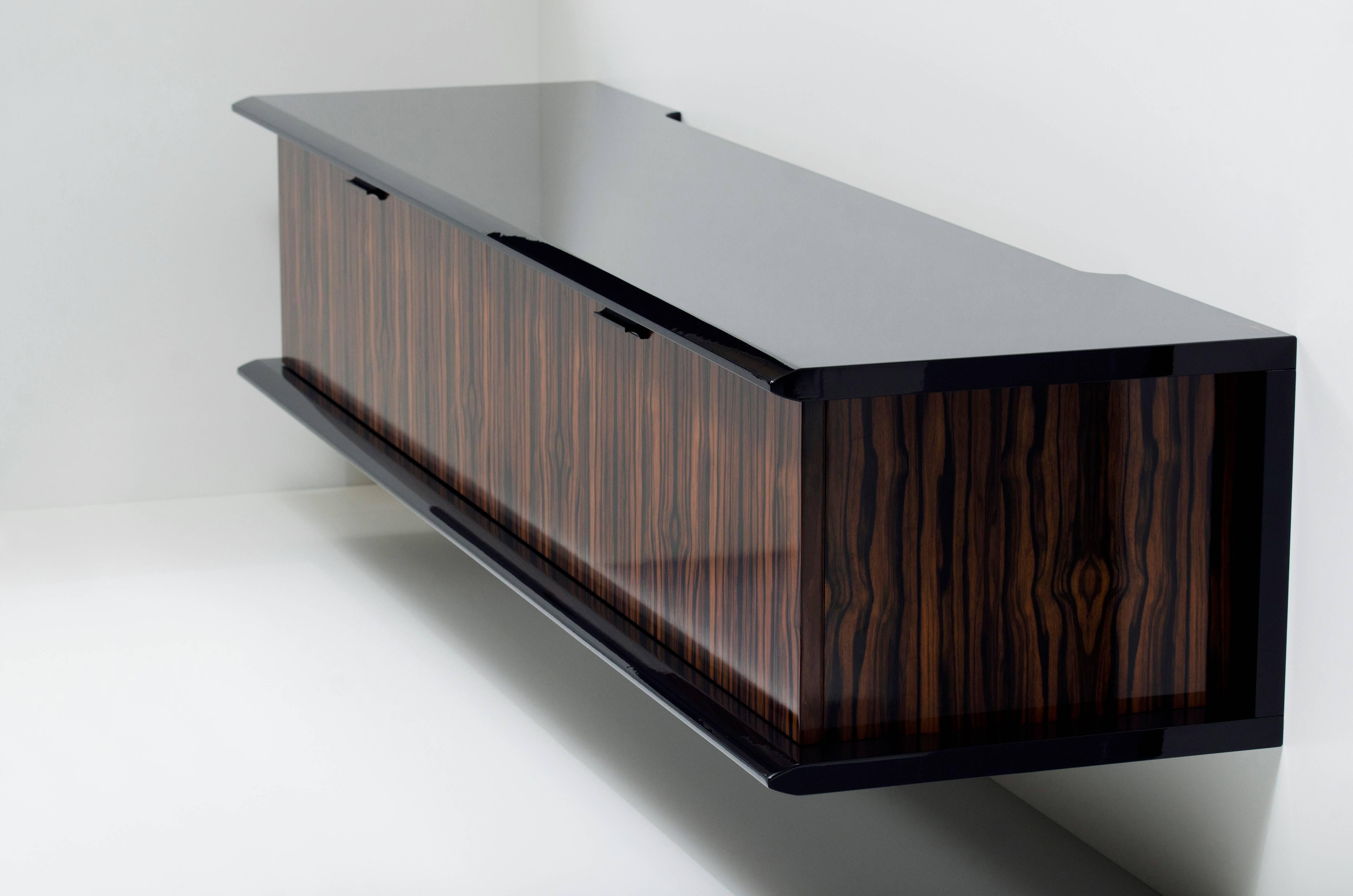 Shown in Macassar ebony and black lacquer, with Sycamore interior. The model one credenza by Pipim is customizable to any dimension and is available in a variety of woods, stains and lacquers. Multiple interior configurations are available. Each