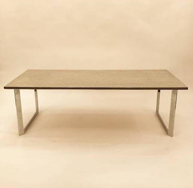 Large scaled rectangular cocktail table featuring a frame in chromed steel which supports a top composed of stripes of small, buff colored tiles in set into an off-white cement. In the style of Georges Jouve, France, circa 1960.