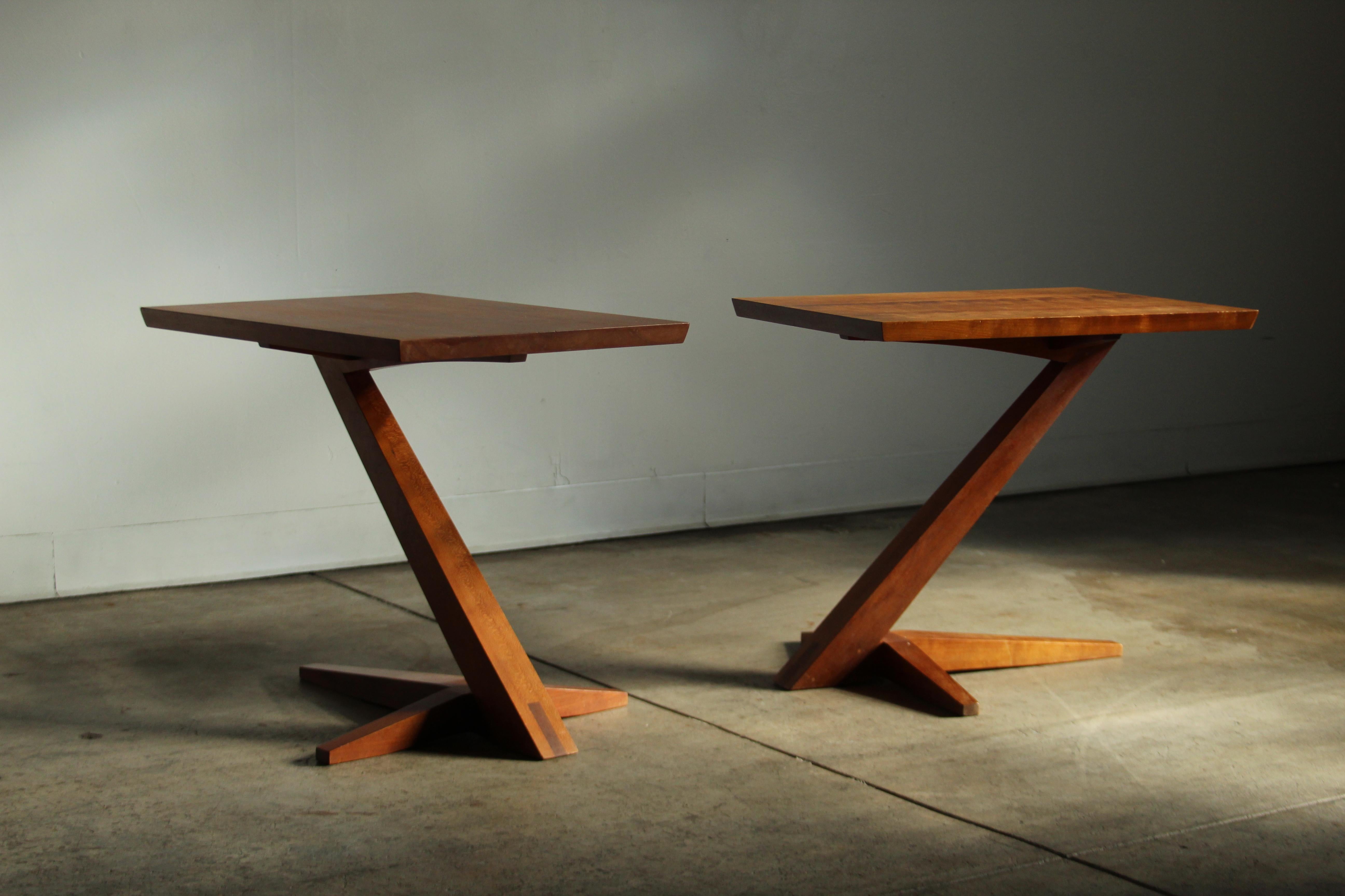 A divine pair of Japanese inspired cantilever end tables by Thomas Moser, crafted in solid cherry. The legs and feet taper as they rise, hand-hewn to form crisp, concise edges. The feet culminate at the base of the leg in a complex mortise-and-tenon