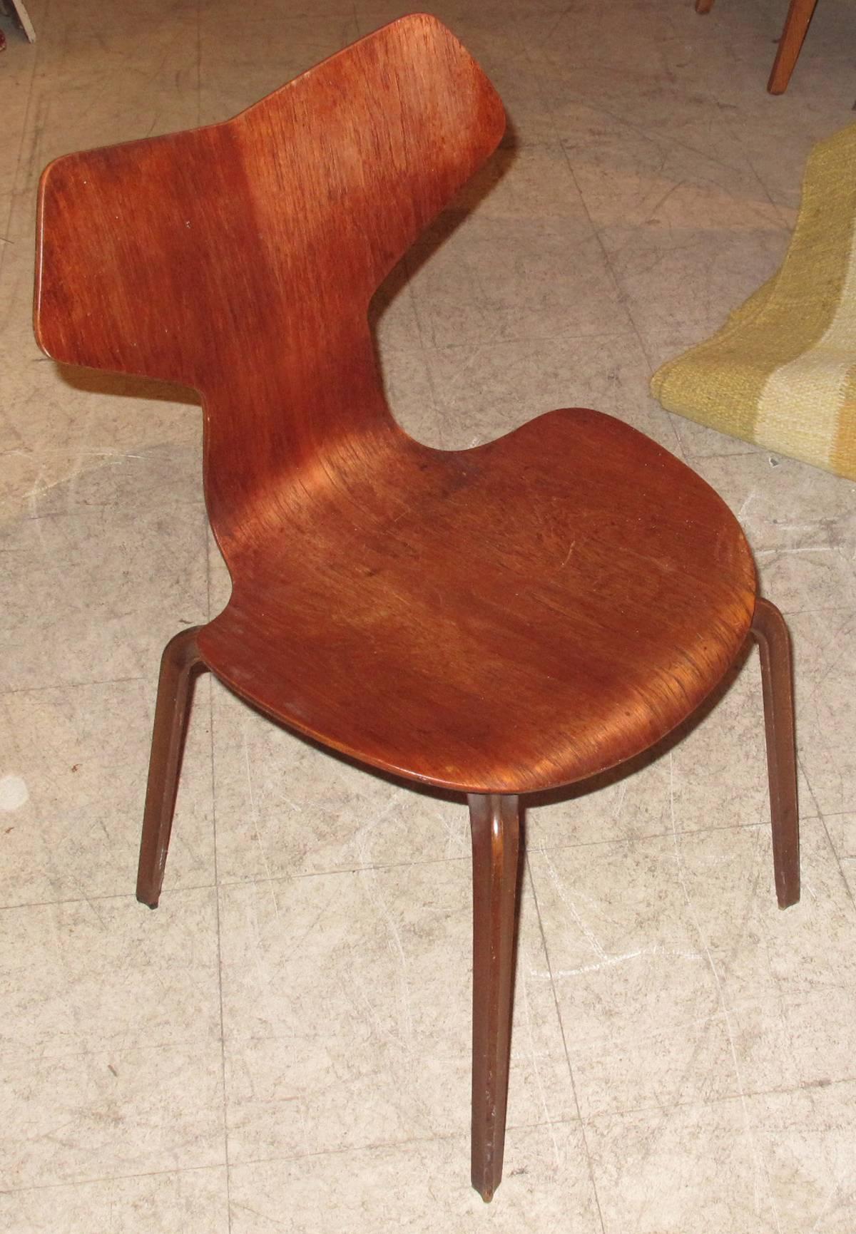 Set of four molded figured teak "Grand Prix" side chairs by Danish designer Arne Jacobsen. Made by Frits Hansen, circa 1950s for Danish High-End Retailer Illums Bolighus (see attached detail photos of stamp and Bolighus metal plate affixed