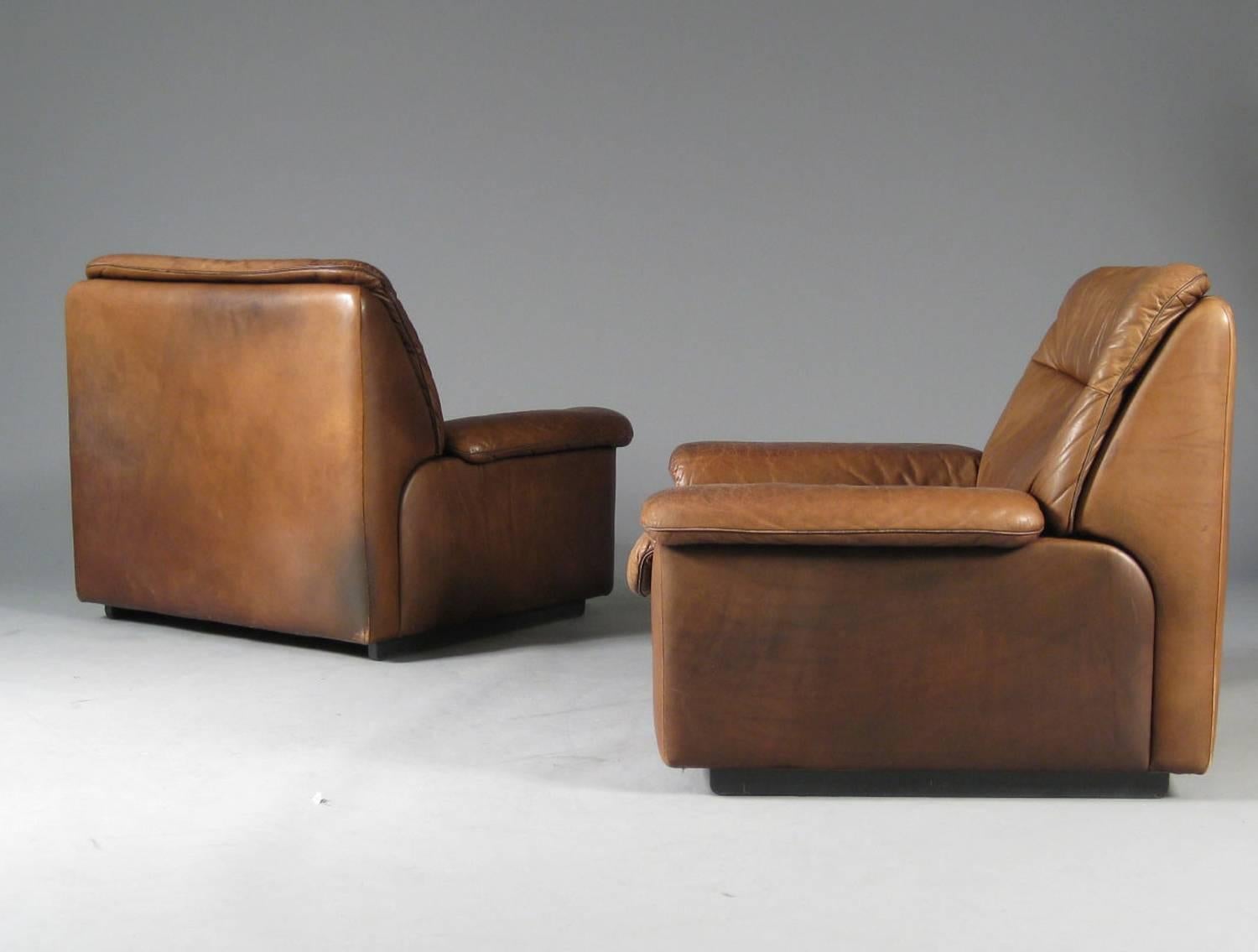 Pair of 1970s leather club chairs and ottoman by luxury furniture maker De Sede of Switzerland. Very comfortable luxuriously
Sized chairs.