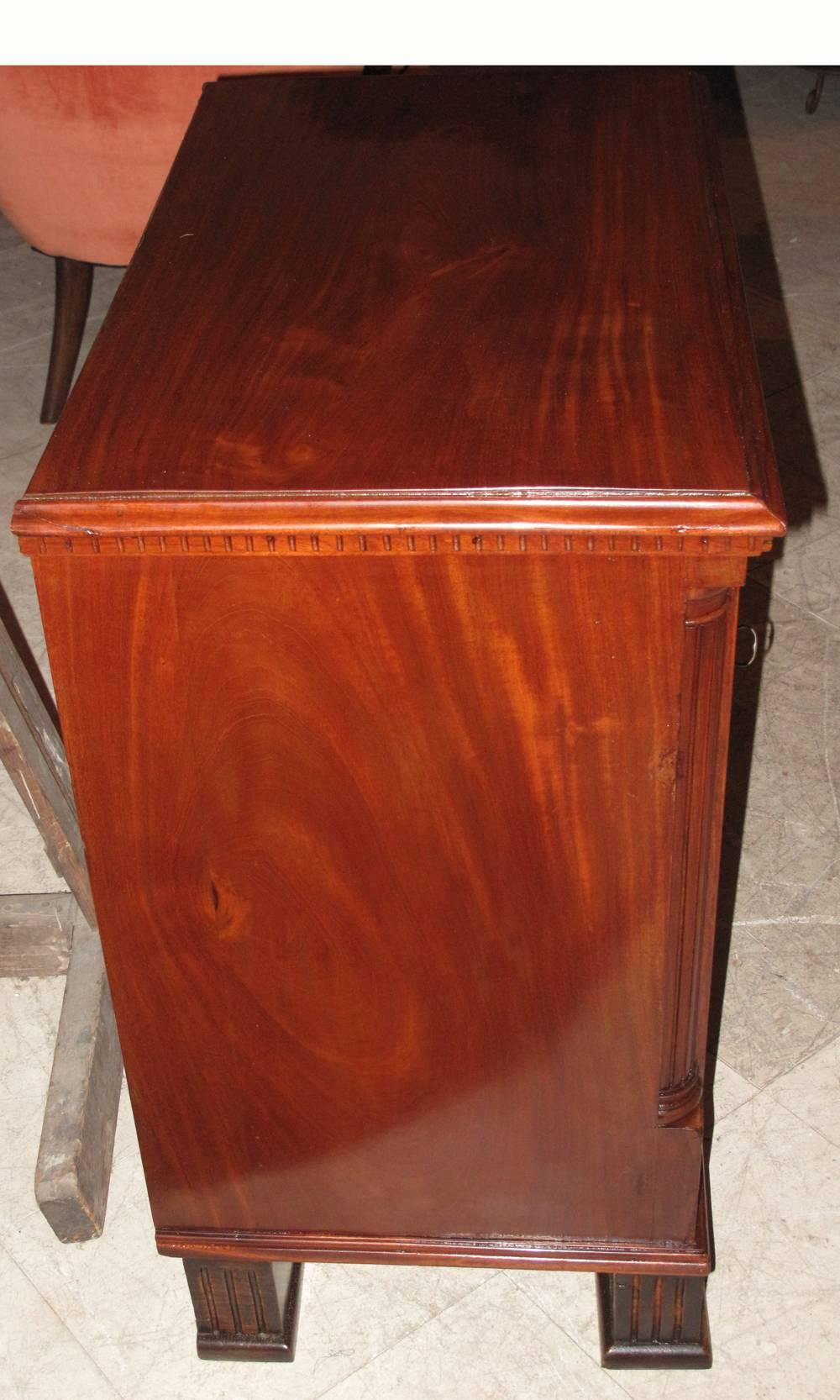 A late 18th century Danish chest of drawers of rich brown figured mahogany the molded top over a dentil molding over three drawers, the drawers flanked by reeded quarter columns on each side above a molded base raised on square column feet. A good