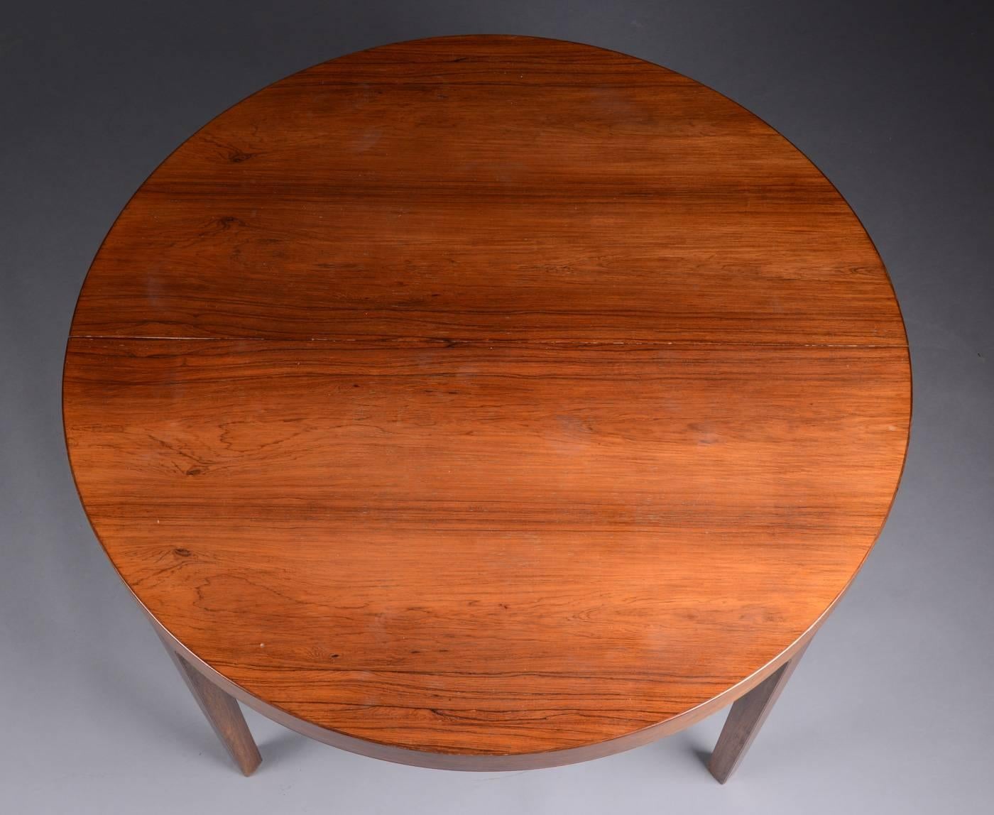 Danish 1960s extending dining table of nicely figured rosewood, circa 1960s, by Designer Ole Wanscher. The table is 49