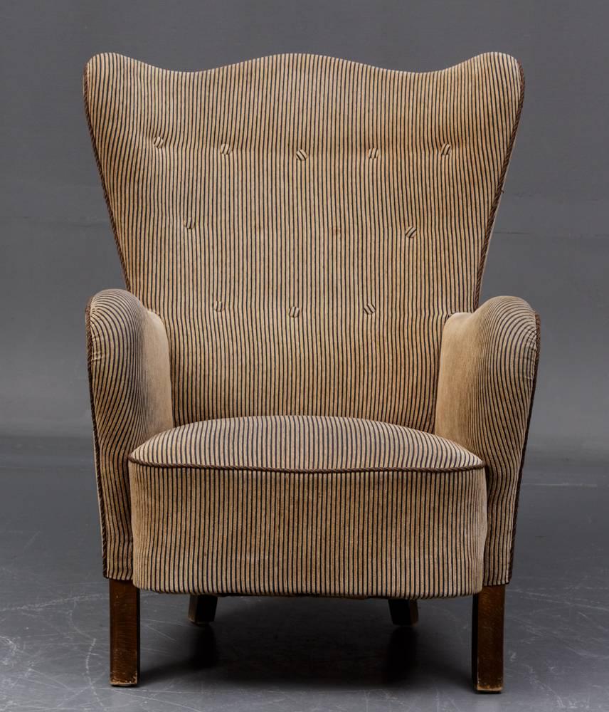 Comfortable and stylish, well-built Danish modern armchair from the 1940s 
with a high wingback, original upholstery in a grey/beige stripe. Legs of 
stained beech.