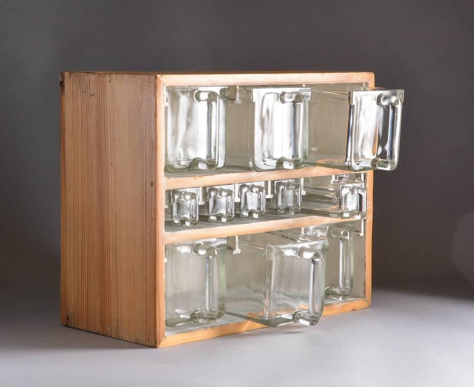 Rare spice rack manufactured by the fine Swedish glass maker Orrefors. The rack comprised of an oak frame with an interior fitted with pull-out small and large glass pitchers stamped Orrefors.