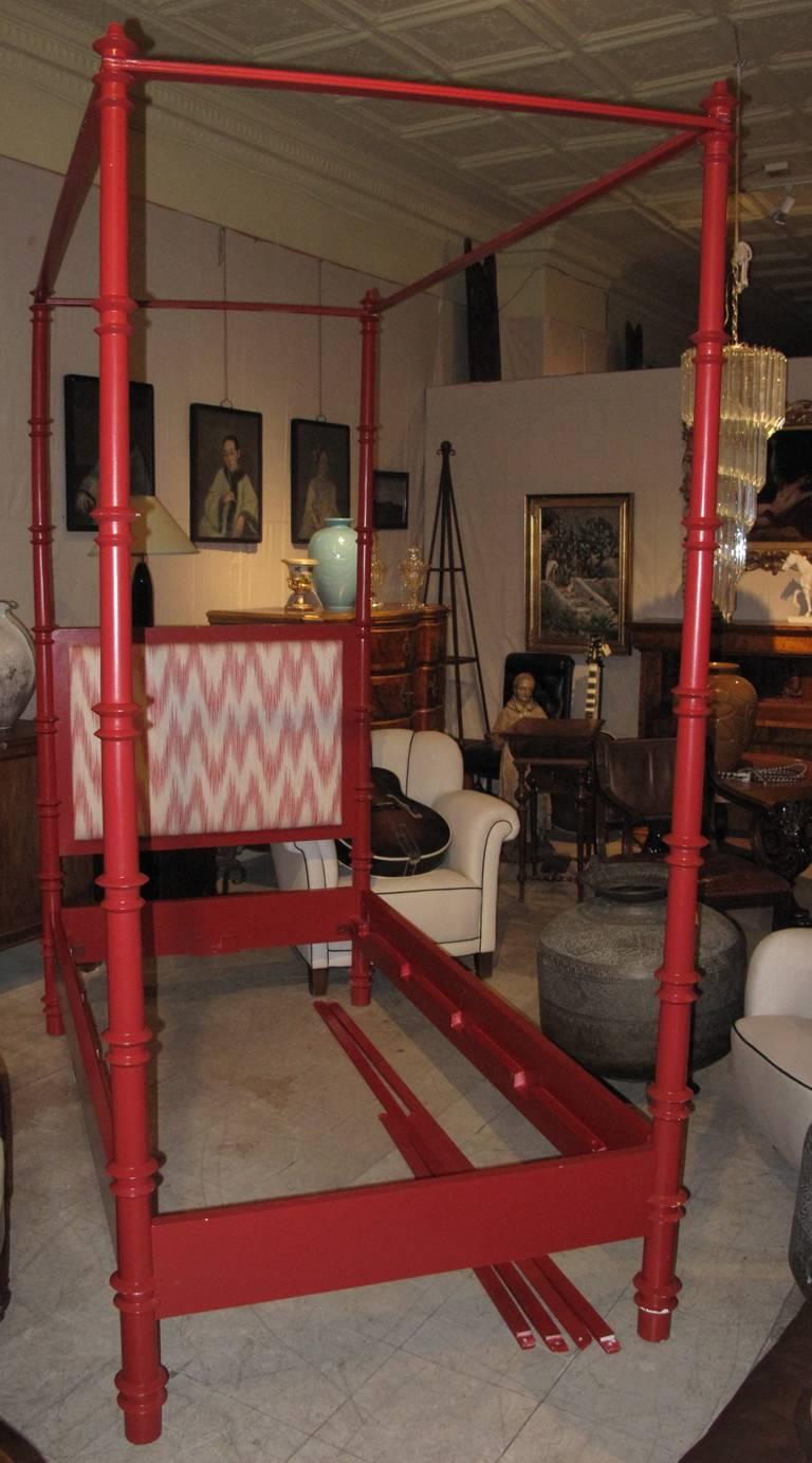 Pair of red painted four-poster bed single canopy bed frames. The beds with four turned bed posts and fabric upholstered head boards. Measures: Length is 76