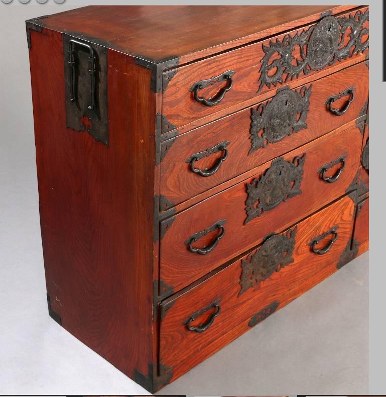 A high quality Japanese elmwood (kayak) "tansu" chest of drawers with elaborate iron mounts chased with dragon motifs. Meiji Period, c 1890