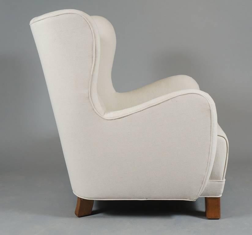 Pair of large-scale Danish 1930s-1940s armchairs by Danish designer Kai Fisker  of ourstanding architectural form. The chairs raised on beechwood legs.