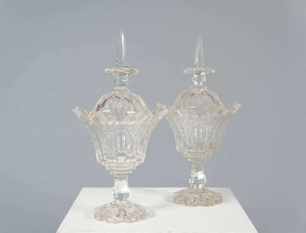 Pair of Anglo-Irish cut-glass compote Jars and covers. Each bell-form bowl with flared rim, on octagonal stem and lobed base, the cover with obelisk handle, circa 1850s-1860s.

