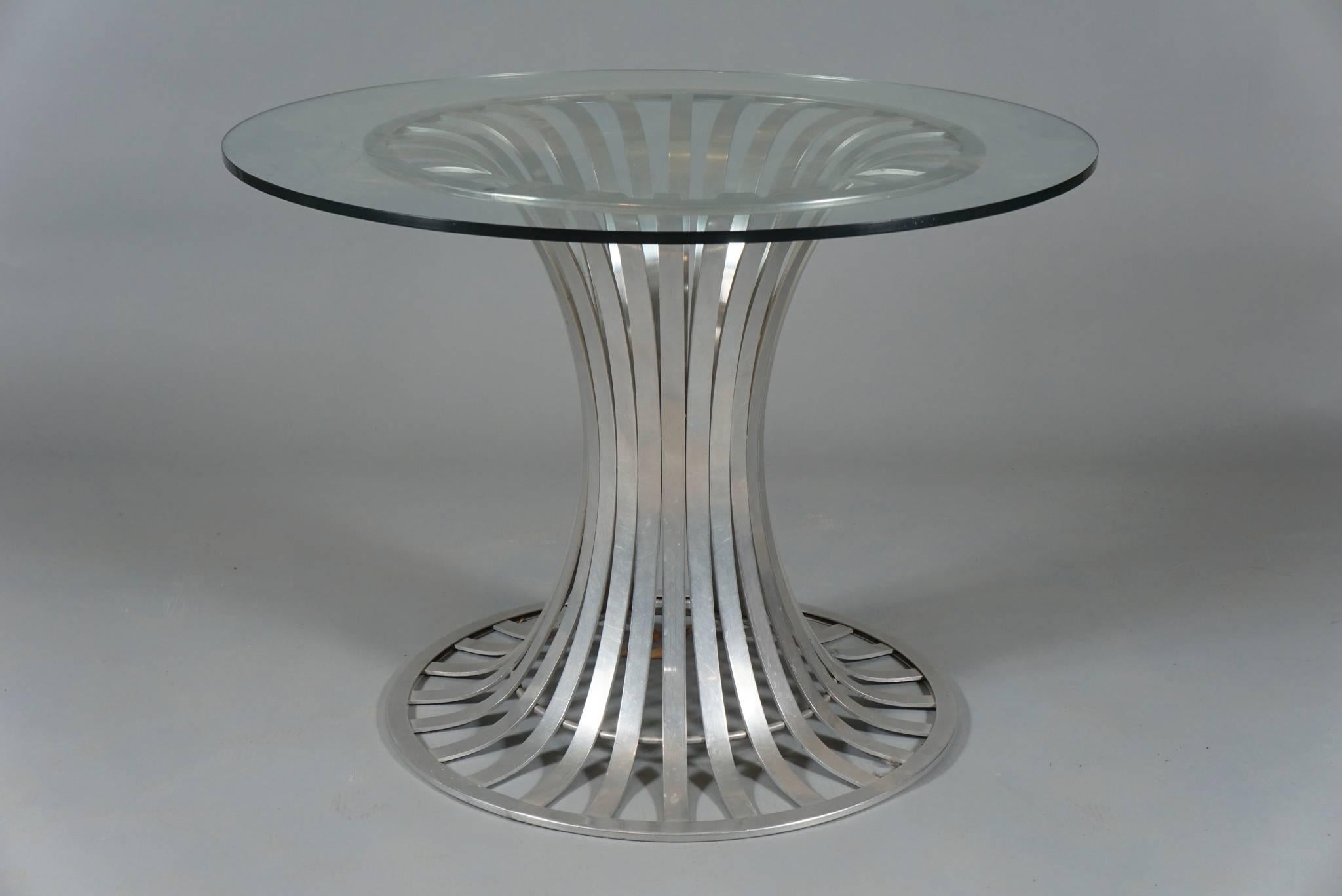 Three-piece patio set by American Furniture Company Woodard, in aluminium
comprising a round glass-topped table and two chairs. Table dimensions below. Chairs measure: 26
