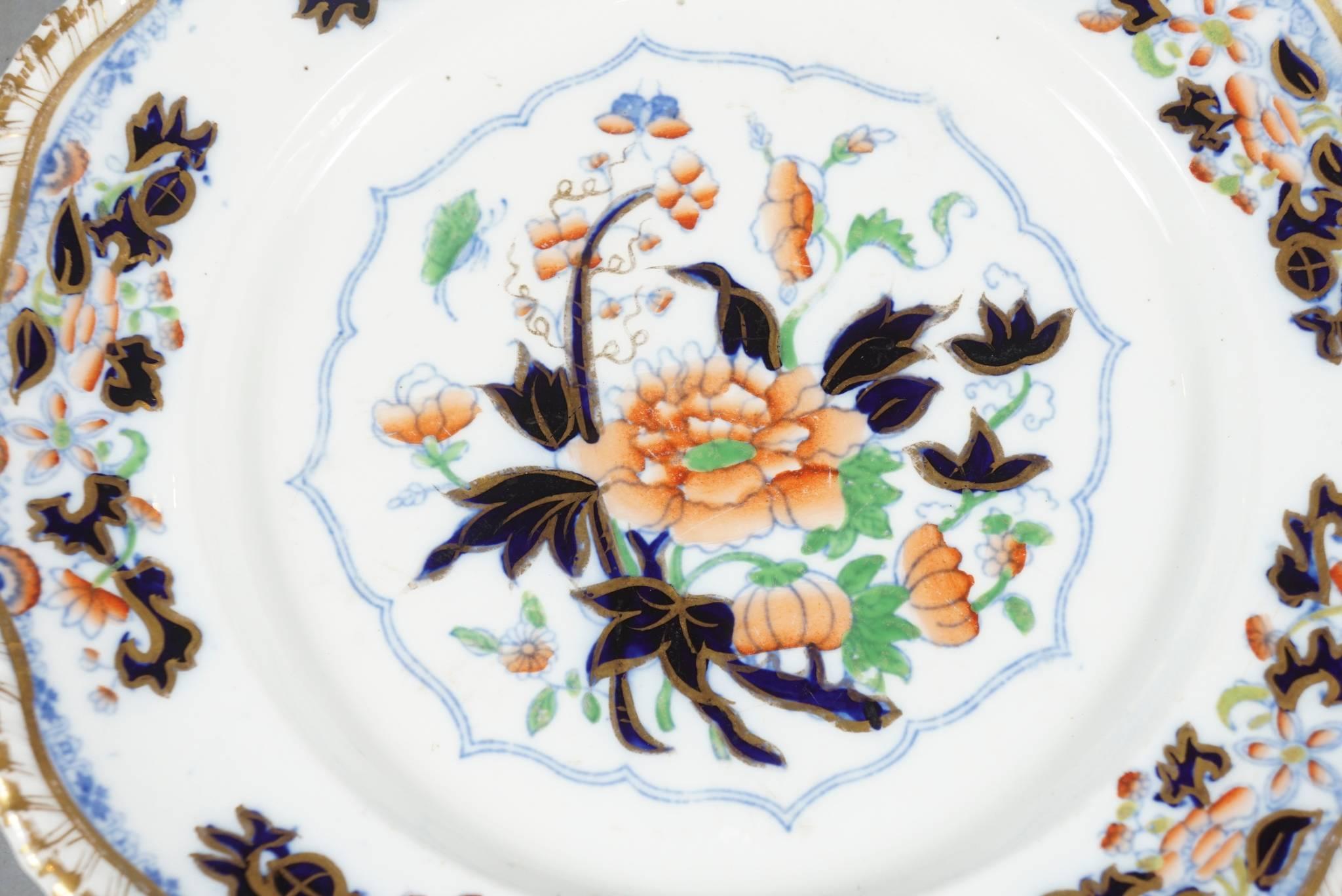 Eight English dinner plates of early Worcester Ironstone pottery in the Imari pattern, blue and red with gold scalloped rim.  The plates are beautifully hand-painted with superb rich enameling and hand gilding and signed on the back in underglaze