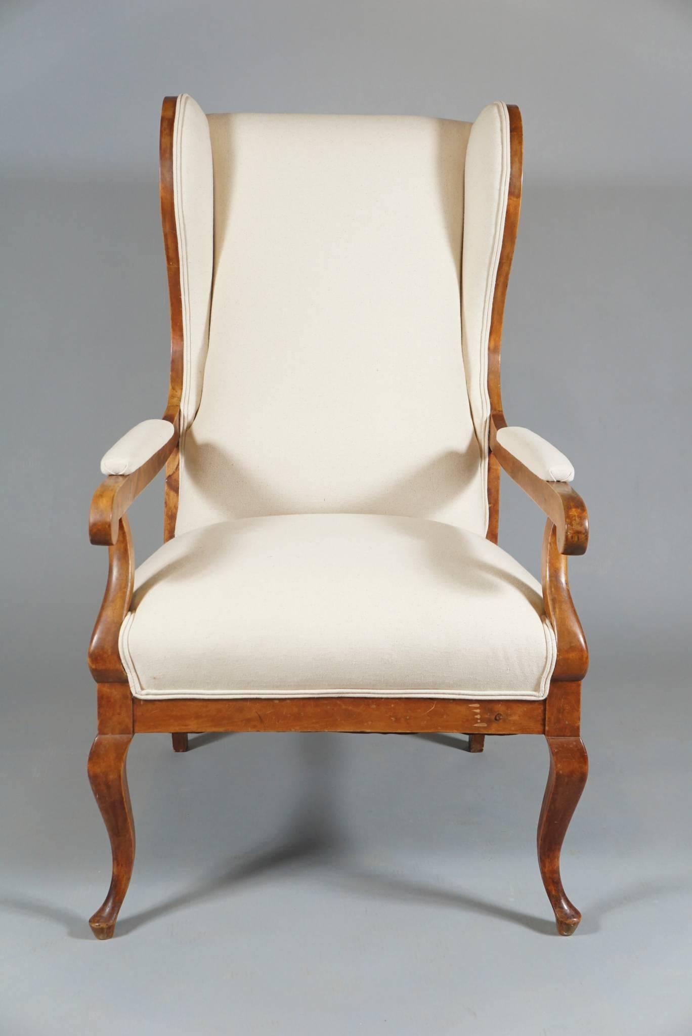 Large single wingback armchair, in birch, with cabriole legs covered in white linen/cotton in a transitional Swedish Biedermeier style.