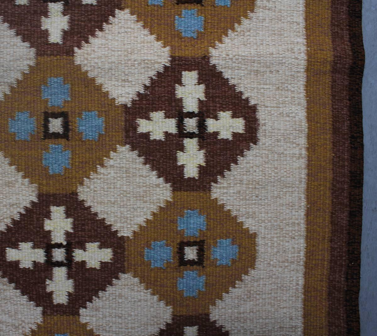 Swedish Rölakan rug in tones of brown, cream and blue. The rug designed by A Wallberg, signed AW, circa 1960s-1970s.