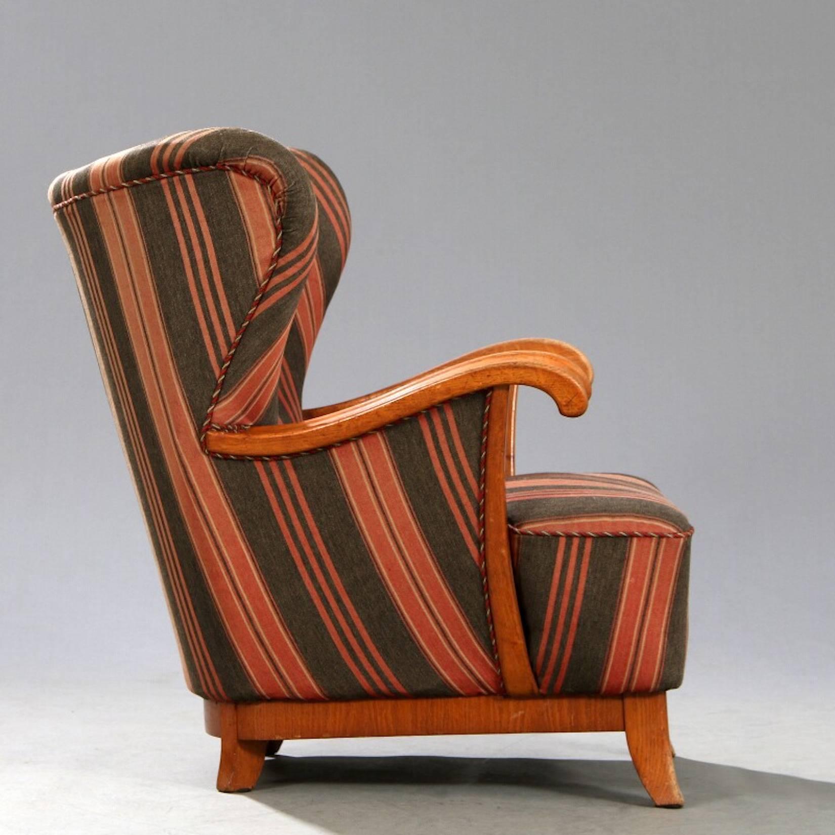 Danish modern cabinet-maker lounge chair, sturdy and comfortable, with oak frame and original striped fabric.