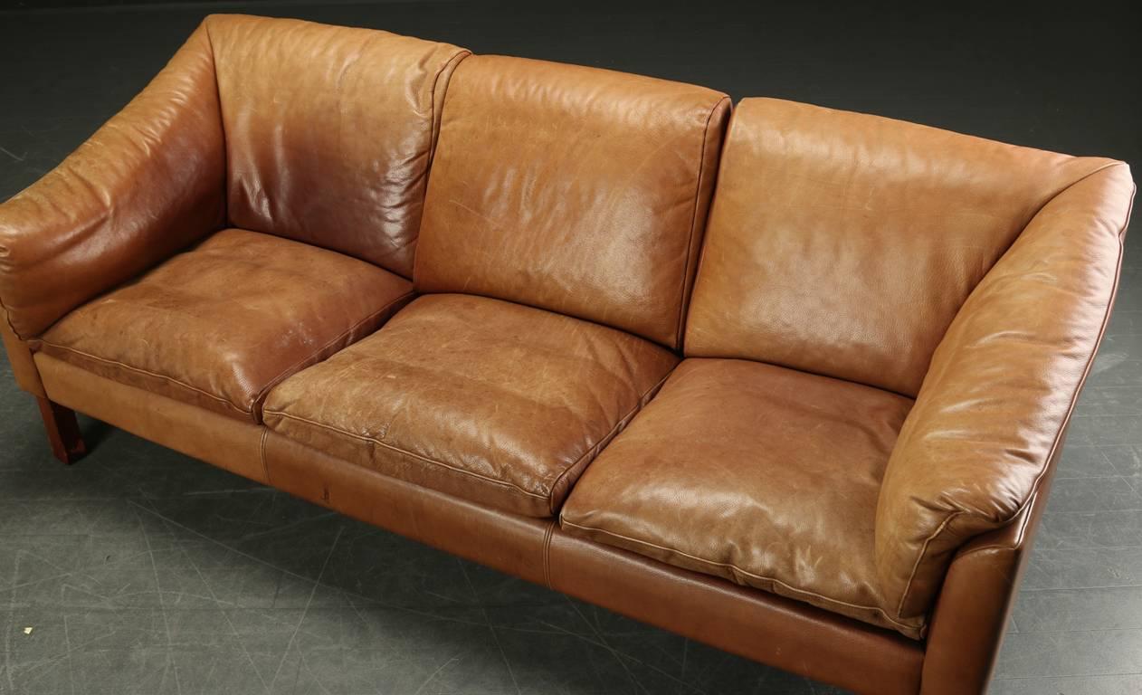 Danish modern sofa upholstered in tobacco colored leather, circa 1960s.