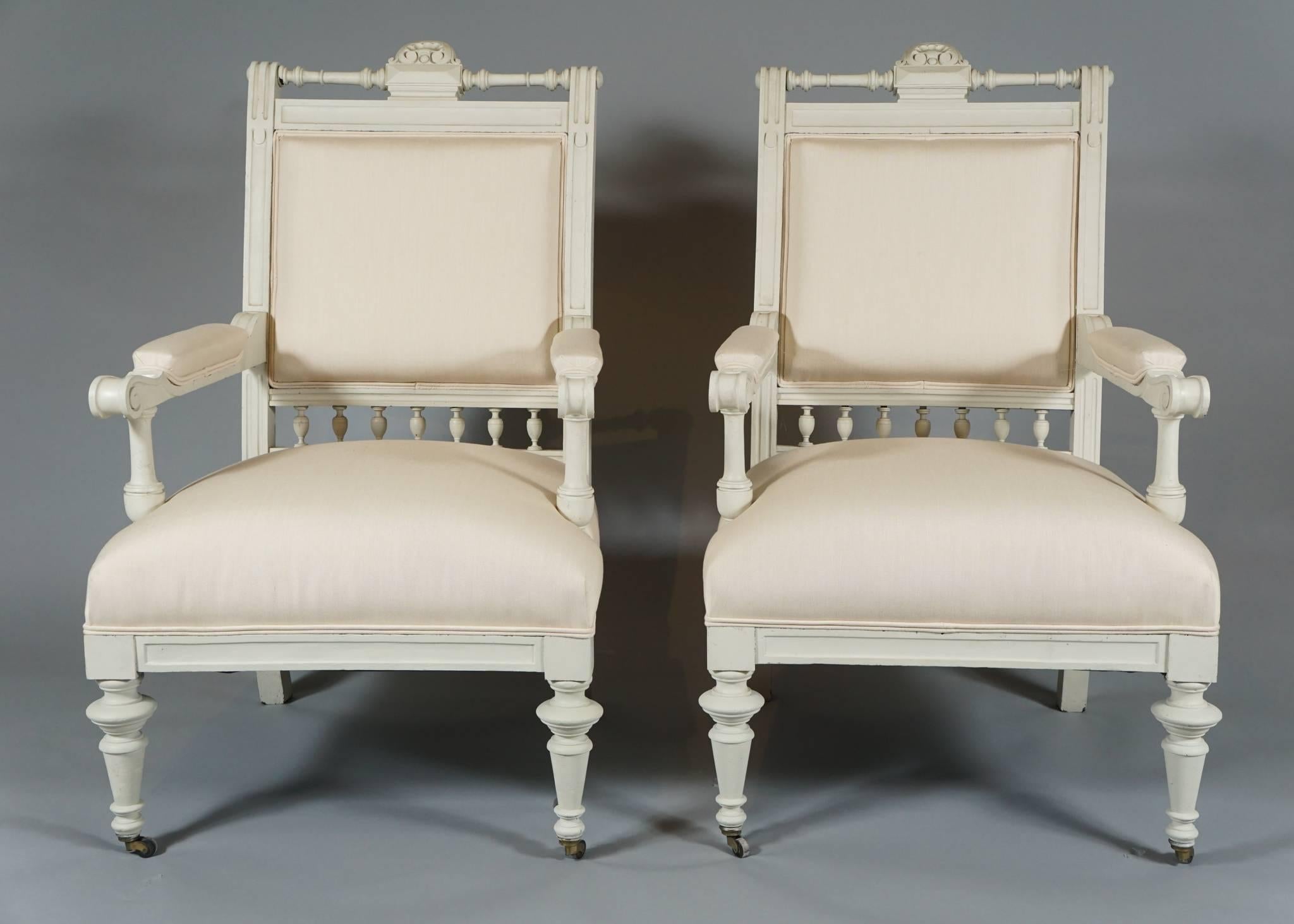 Handsome pair of armchairs from the Aesthetic Movement, circa 1880s, in
white-painted wood with turned legs and spindle decoration reupholstered in white linen/cotton, front legs on castors.
