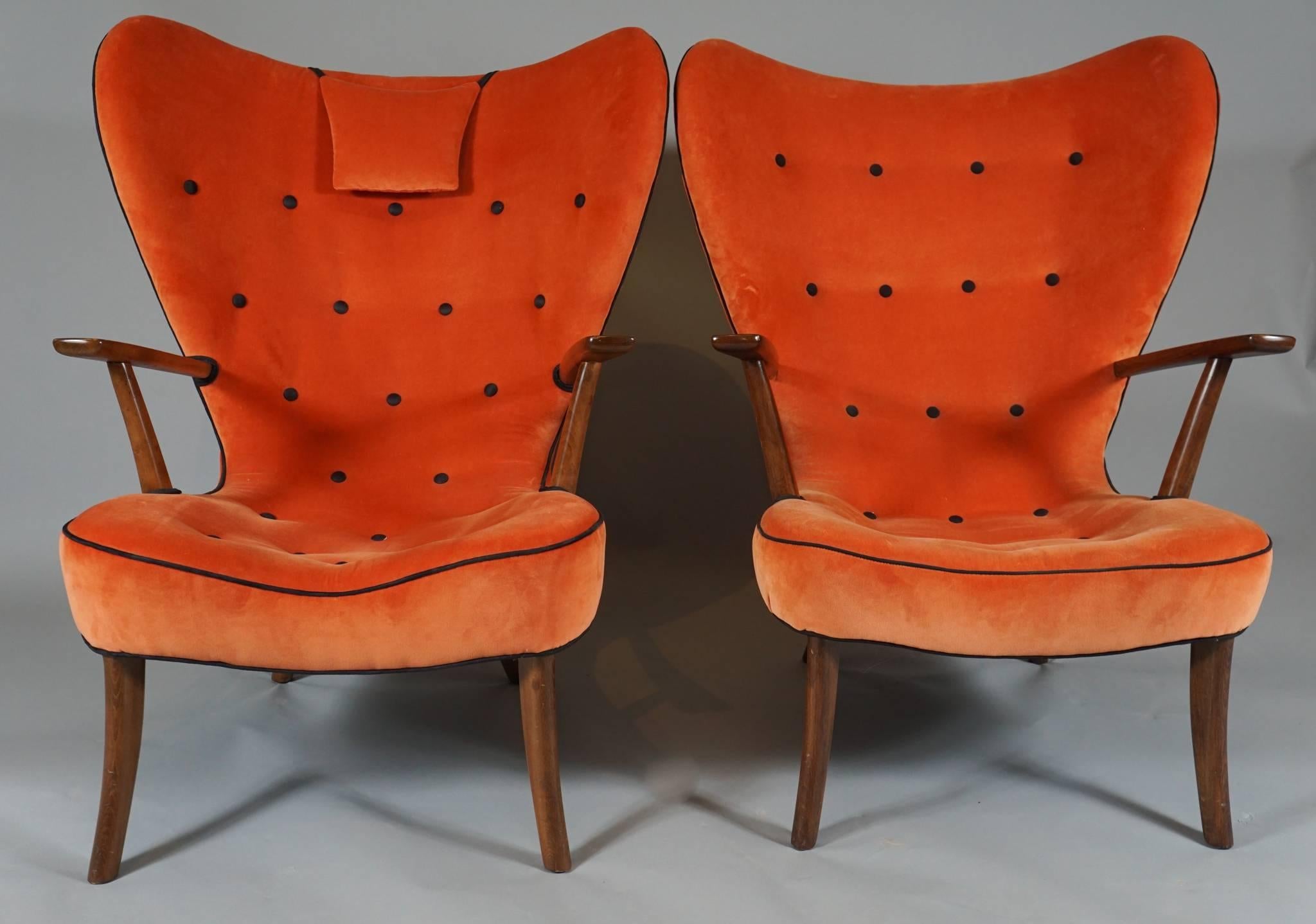 A pair of sculptural armchairs designed by Ib Madsen and Acton Schubell, the Pragh model, 1954, Rungsted, Denmark.
Upholstered in cantaloupe colored mohair with black piping and buttons.
One chair has a head cushion. Other Pragh chairs available