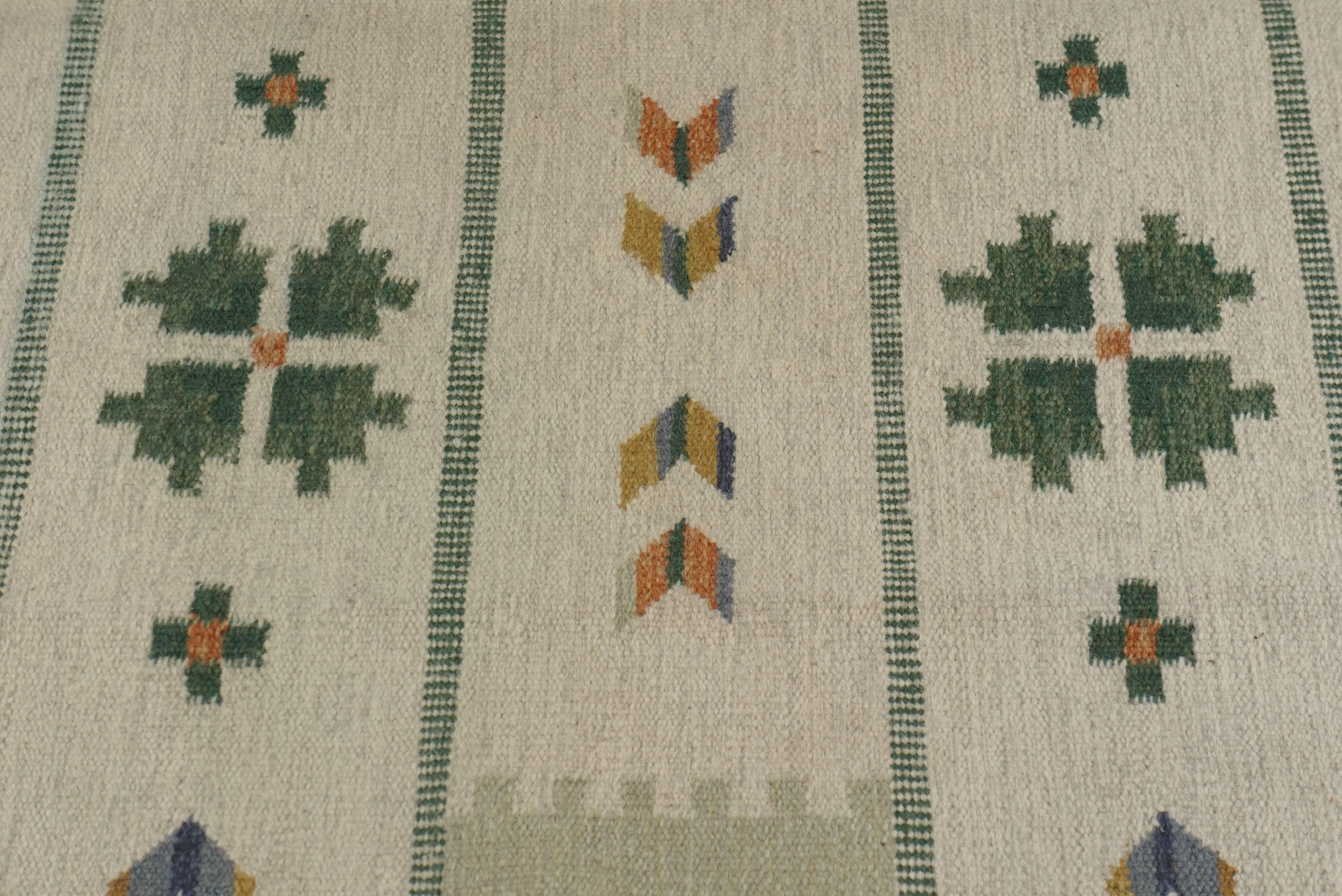 Swedish Rölakan (flat-woven) rug decorated with geometric patterns in off-white with dark green border, circa 1960s.
    