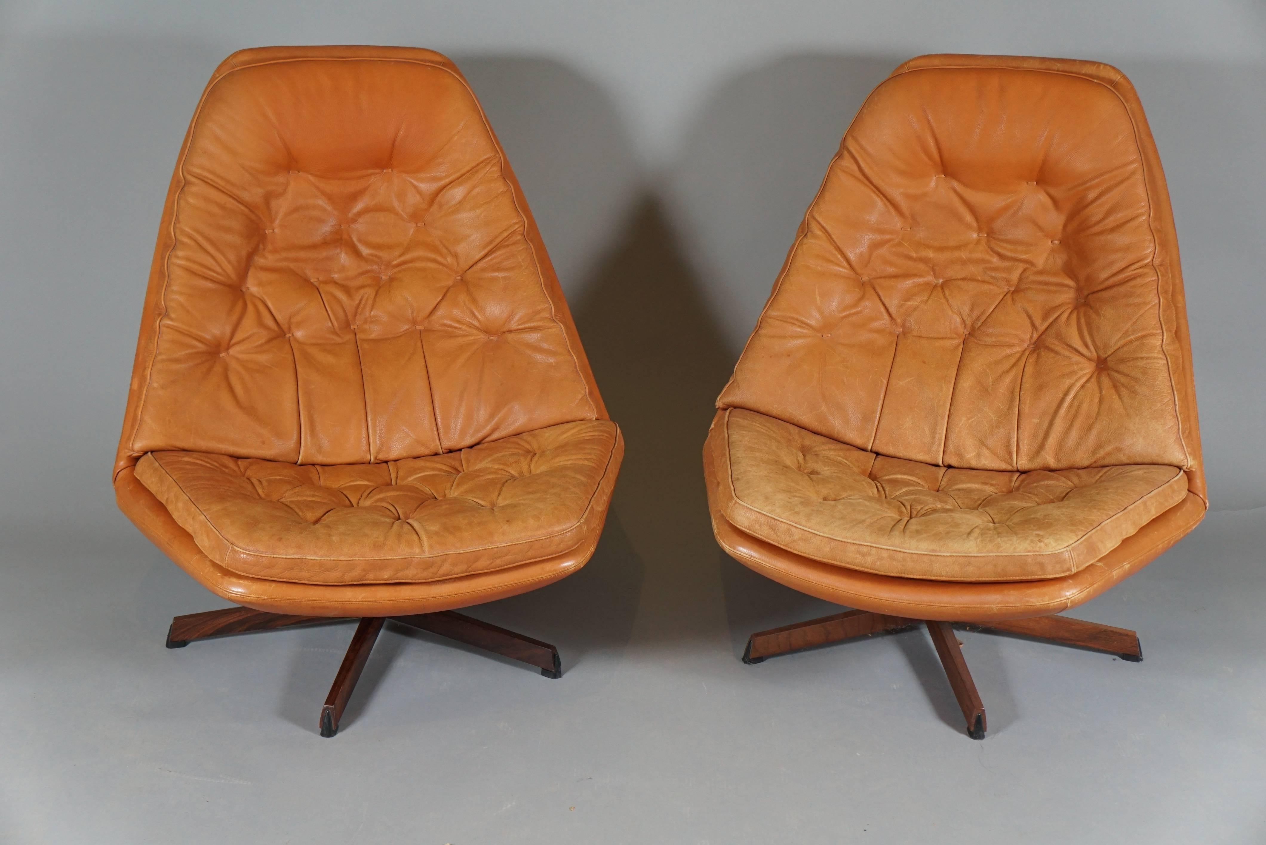 Pair of leather swivel chairs with rosewood bases by Danish designers Madsen & Schubell, circa 1960s. Ottomans are 17