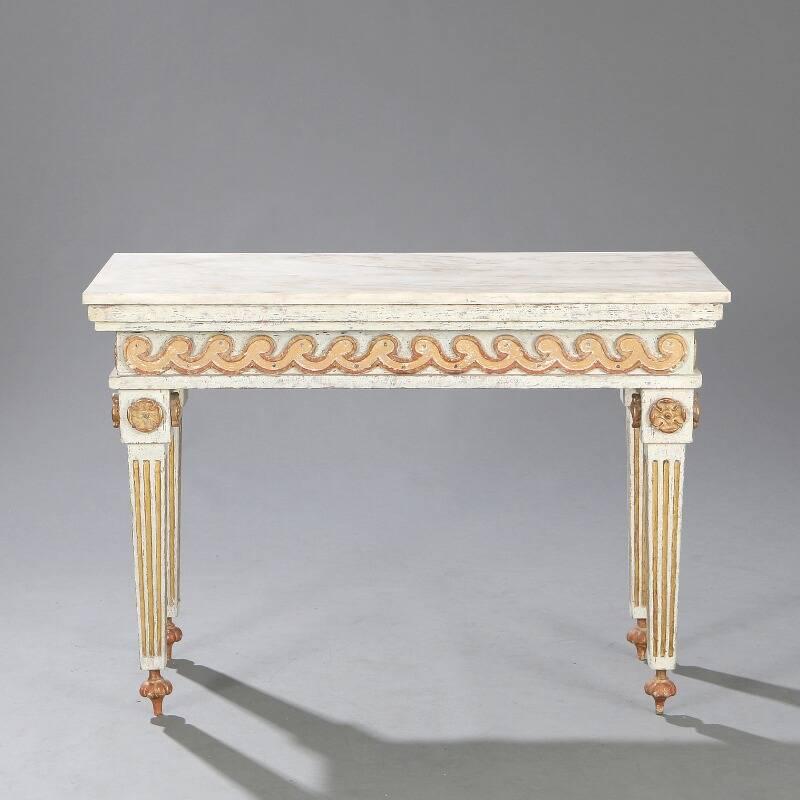 Pair of Swedish Louis XVI style painted and parcel-gilt console tables. The marble tops over a vitruvian scroll carved frieze supported by fluted legs headed by rosette carved blocks and ending in toupie style feet, late 19th century.