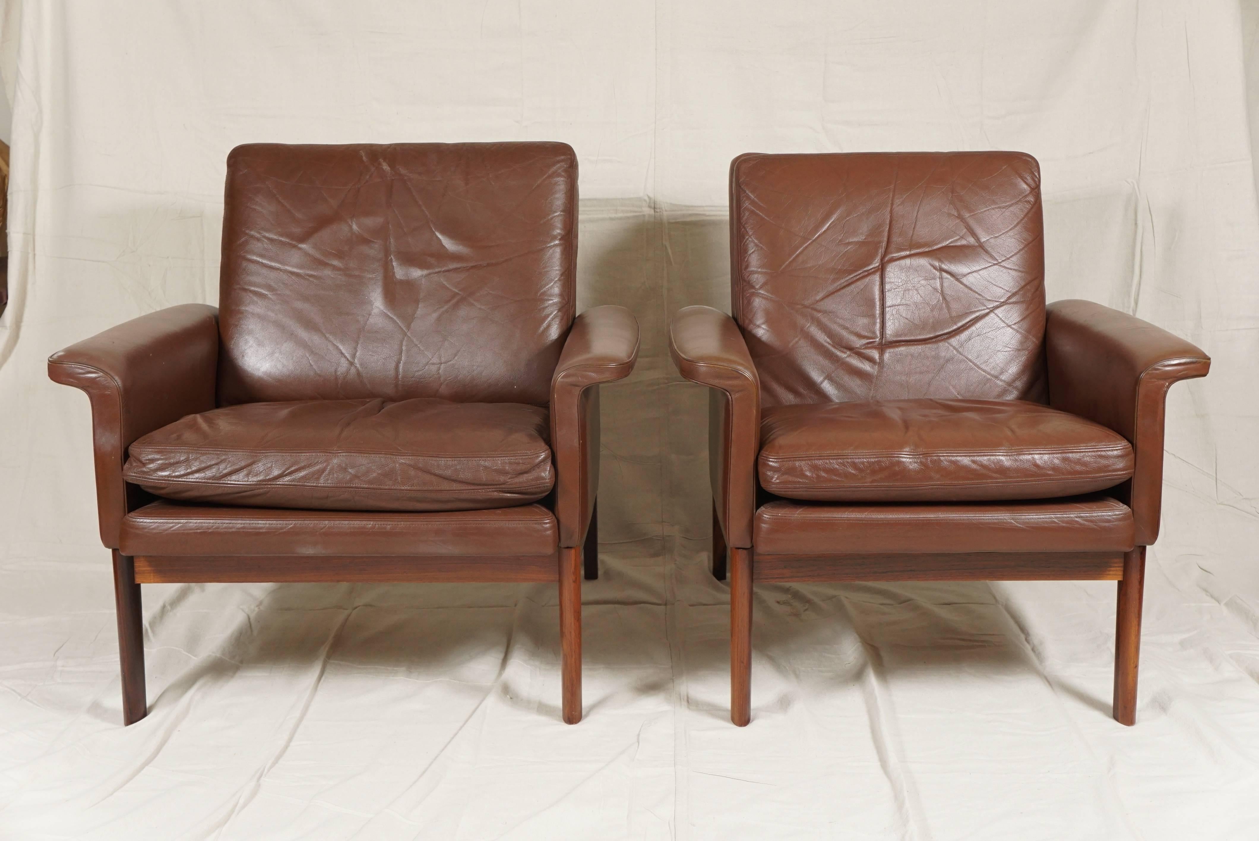 Elegant pair of Danish modern leather armchairs in the style of Finn Juhl covered in high quality soft brown leather with rosewood frames.