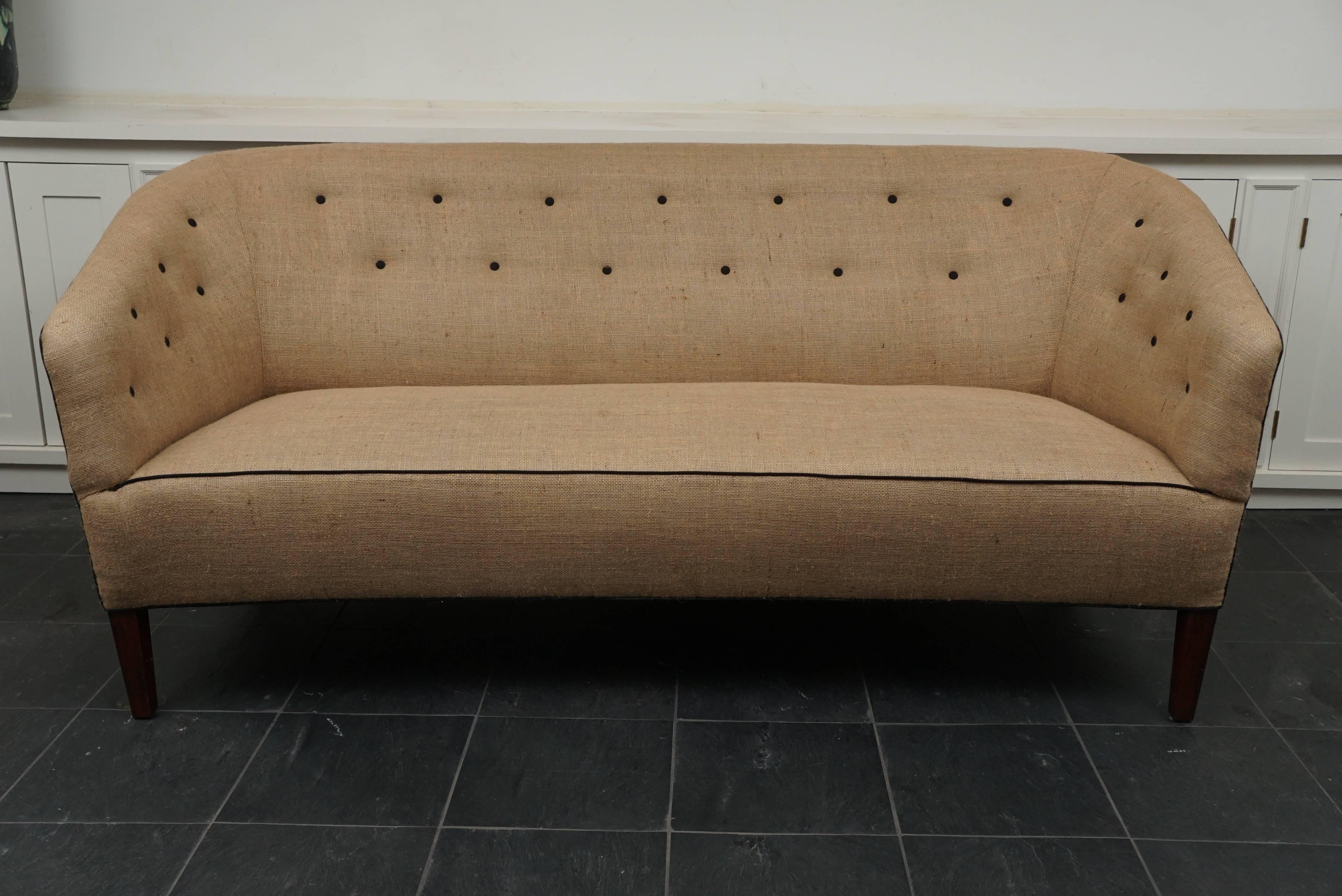 Danish modern three-seat sofa by well-known designer, Louis Pontoppidan,
with buttoned back newly recovered in beige burlap with black trim.