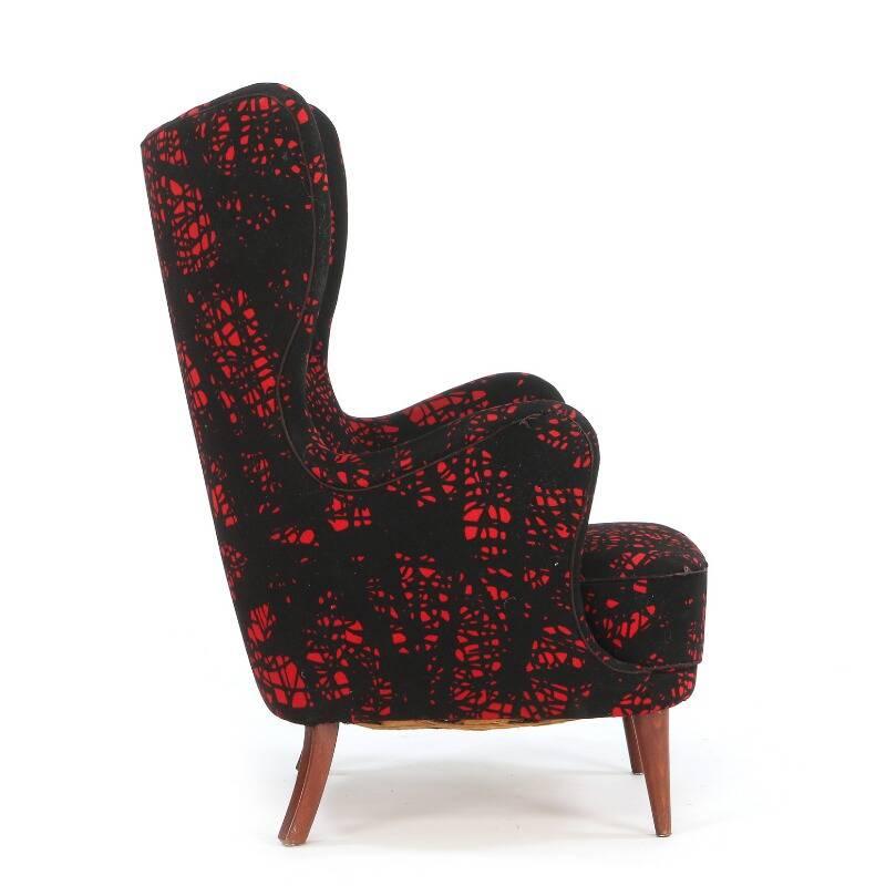 Striking high-backed Danish modern easy chair with exaggerated curved arms and legs of stained beech. Seat, sides, back and neck rest upholstered with patterned black/red wool, 1940s.
 