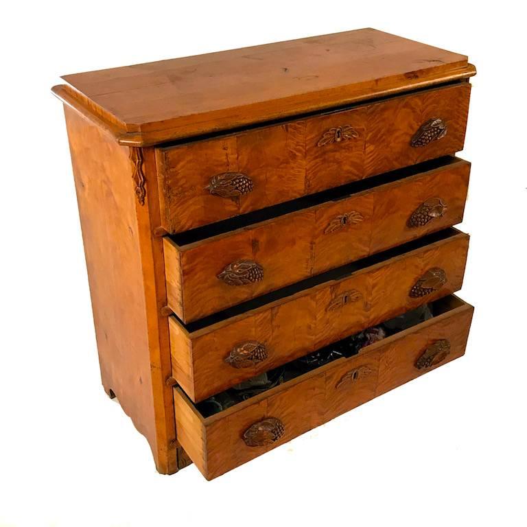 Swedish, 19th century birchwood chest of drawers. The chest with four pull-out drawers with carved leaf and berry handles and leaf carved escutcheons, circa 1870s-1880s.