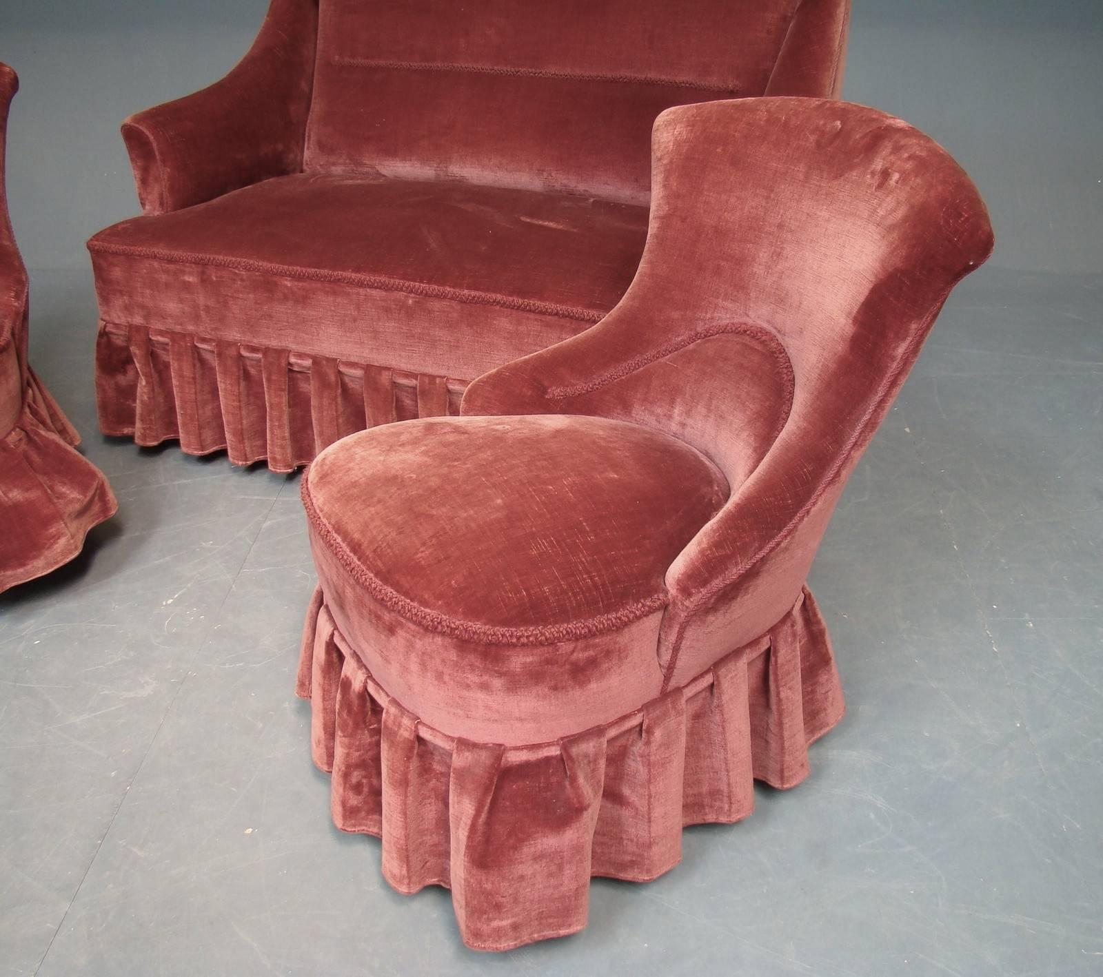 Danish 1930s small-scale salon set comprised of two chairs and a loveseat with skirted velvet upholstery. Note that there is a lot of flash in these photos, but the color of the upholstery is maroon.

The sofa is 36