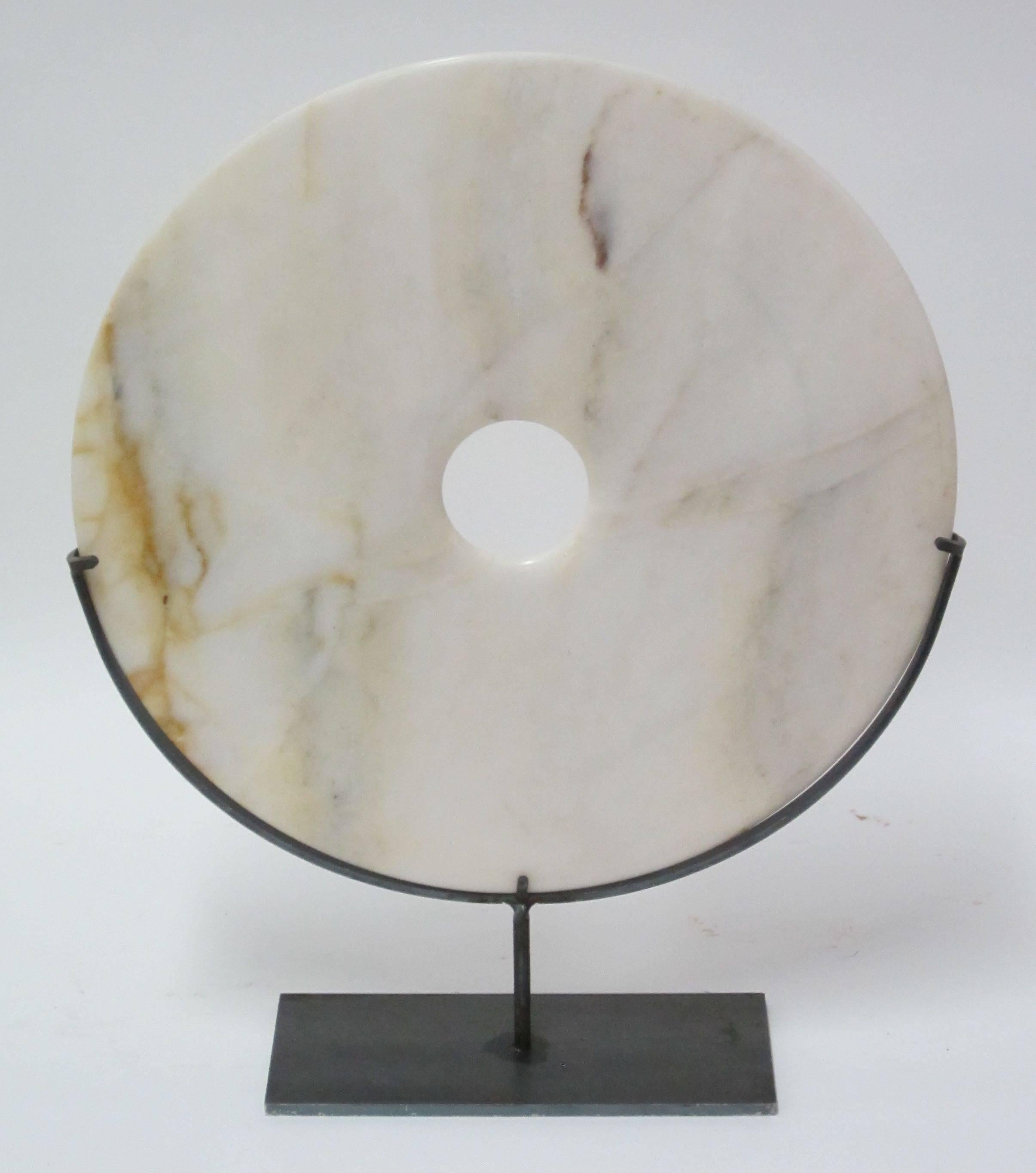 Contemporary Chinese smooth disc sculpture on metal stand.
Disc is cream with brown streaks.

