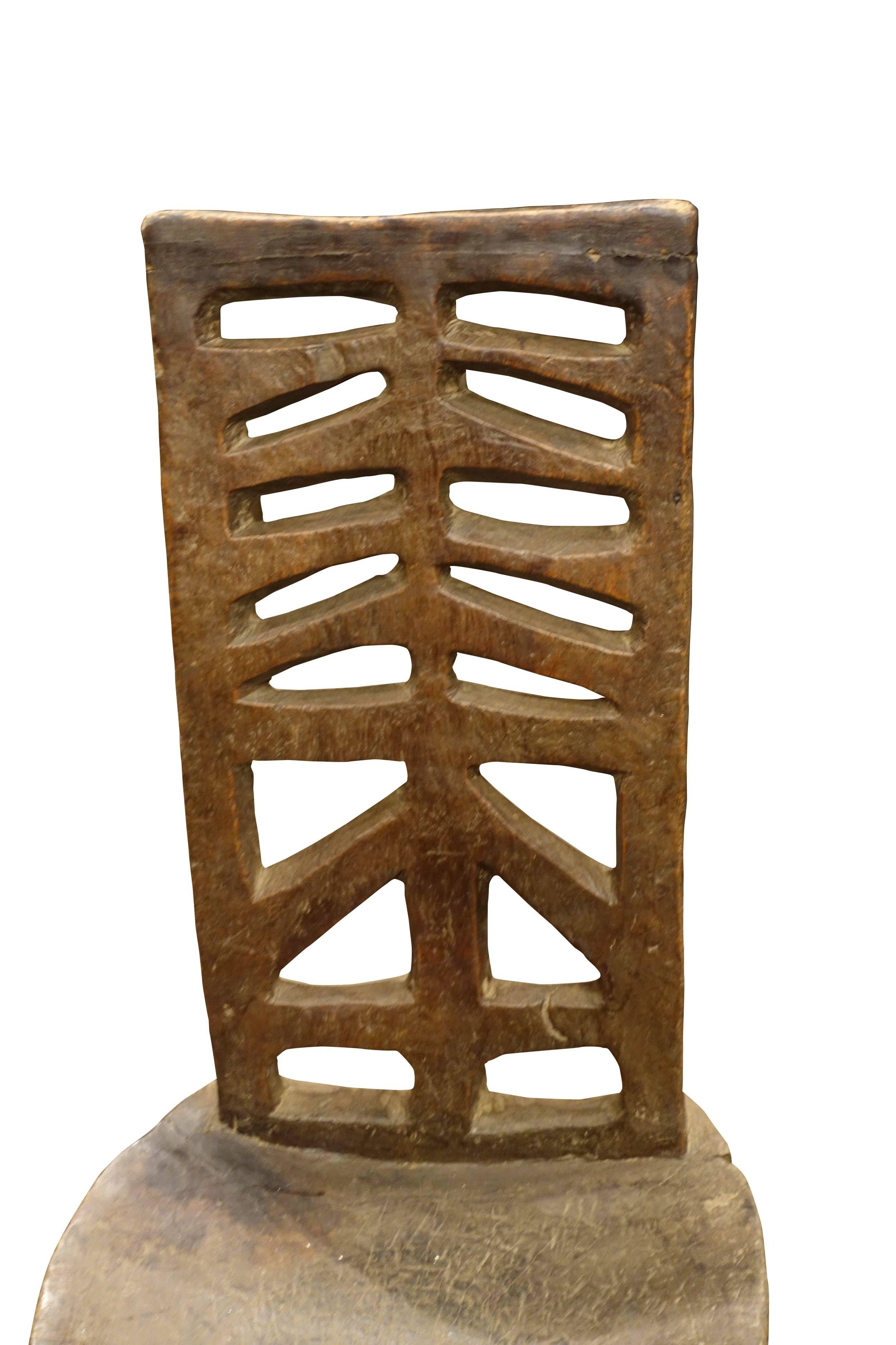 19th century Ethiopian hand-carved mahogany single chair with tripod legs.
Tall carved back in traditional design.
Very decorative.
 