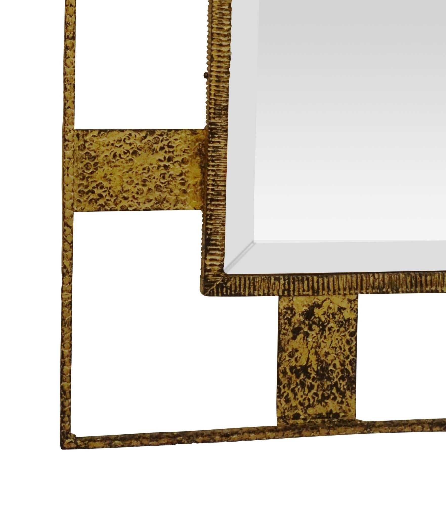 1930s French gold gilt iron framed mirror. 
Decorative blocks of gold gilt iron border the original mirror.