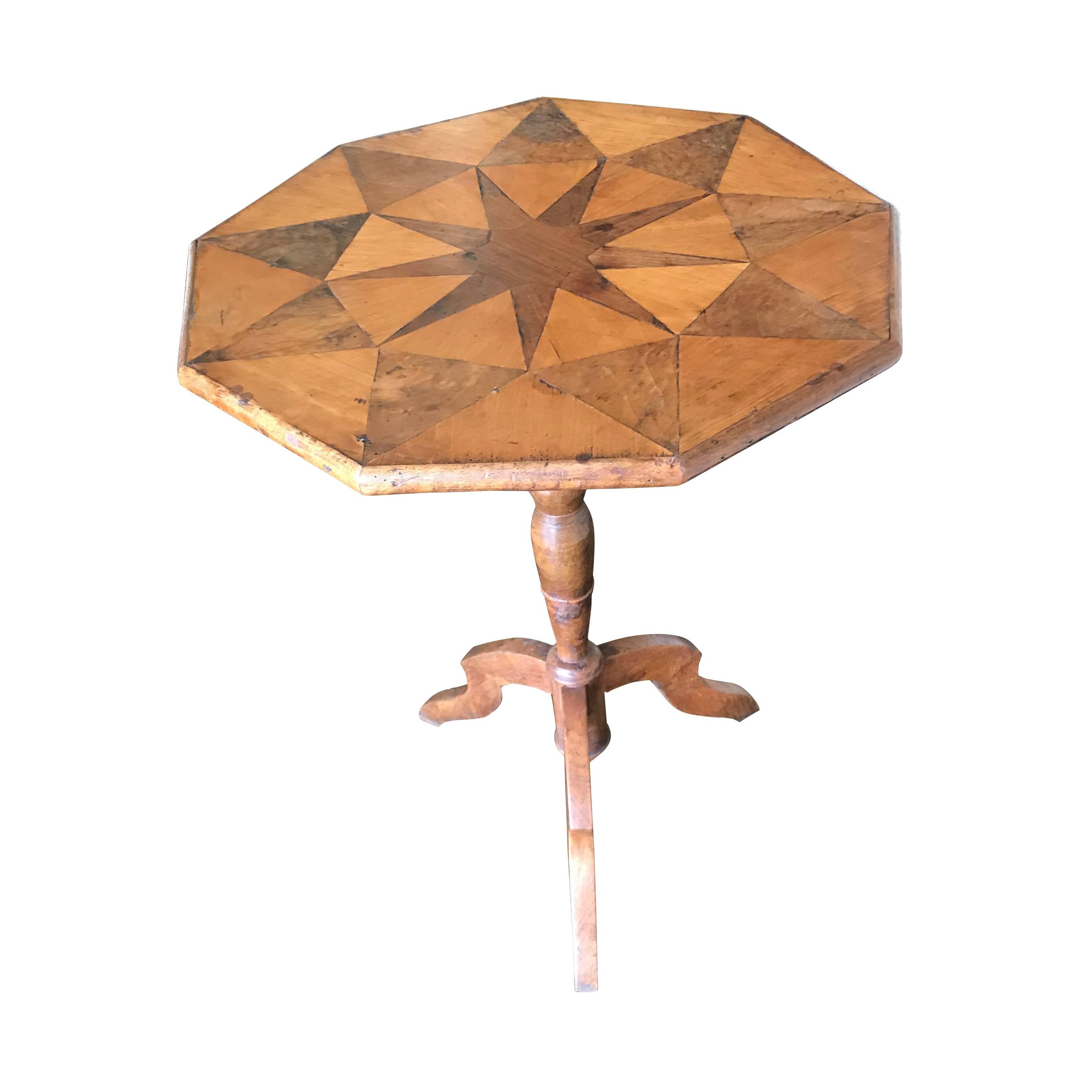 Nine-sided cocktail table with a walnut star and triangles decorating the inlay top.
Spool base and tripod legs.
The table is in excellent condition.