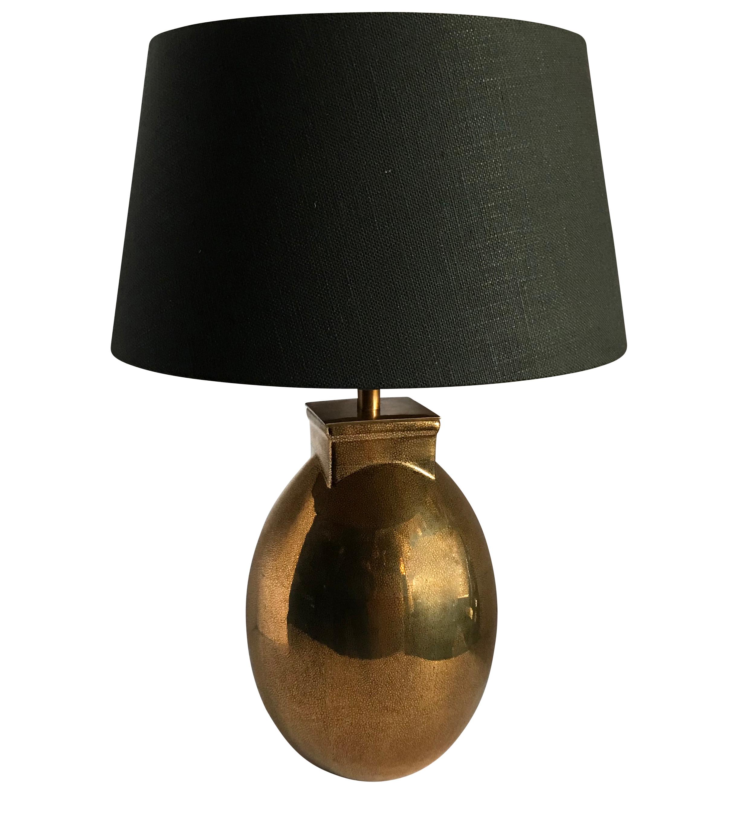 Contemporary pair faux shagreen design lamps with a metallic/brass color
Round lamps with square top
Black linen shades with gold interior lining
Measures: Shade is 16