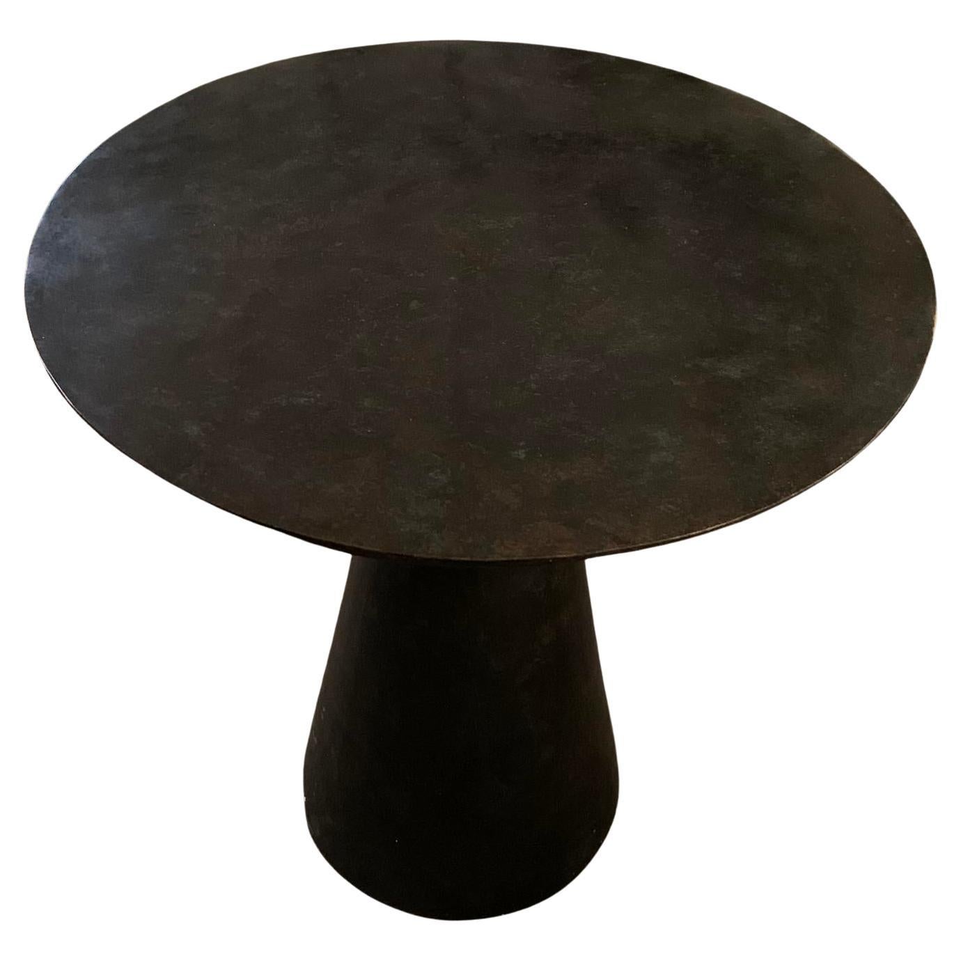 Round bronze side table with smooth top
Bronze tapered cylinder base
Very sturdy and durable.

 