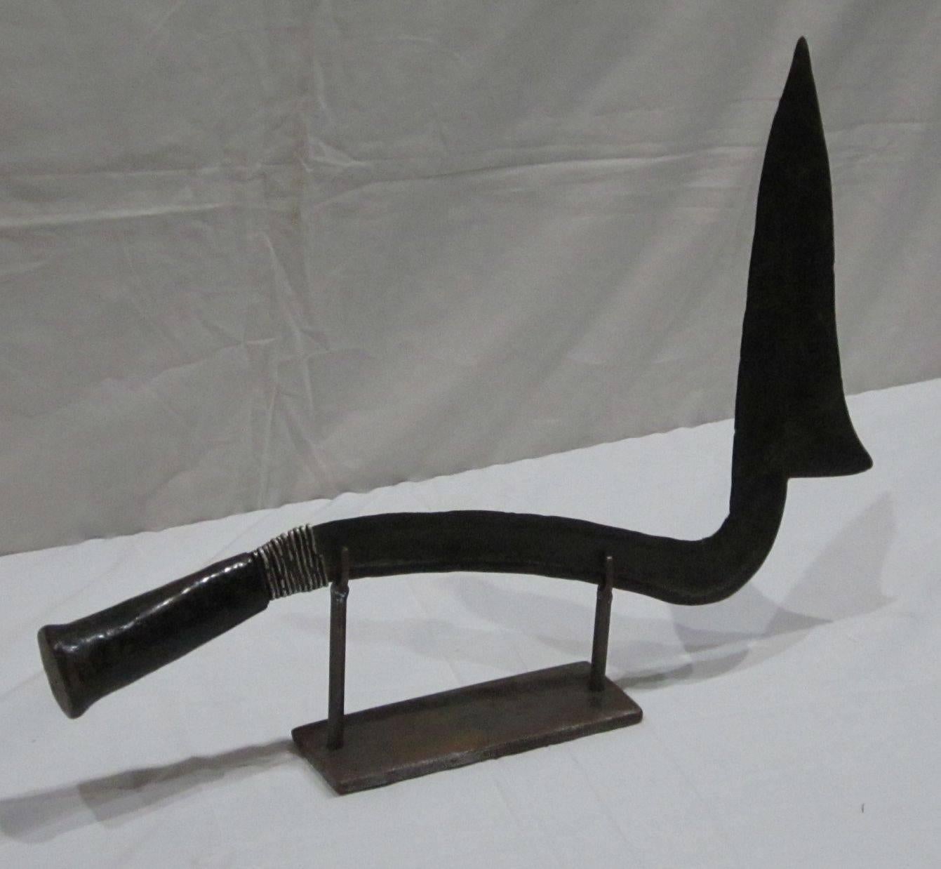 1920s African Congolese sword sculpture on metal stand.
Wooden handle. Base measures 8